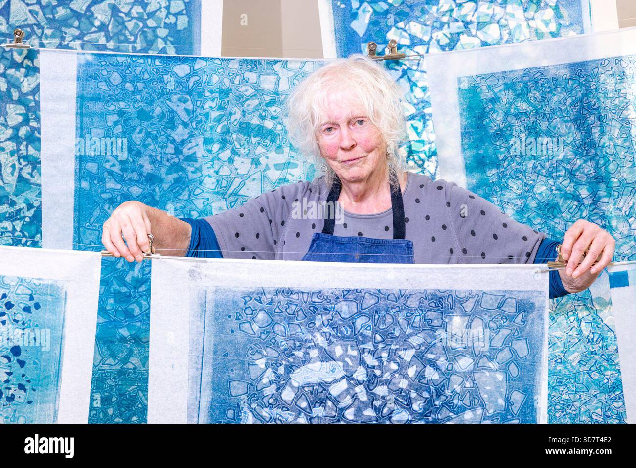 Edinburgh, Vereinigtes Königreich. 25. November 2025 im Bild: Die Künstlerin Mary Walters posiert mit ihrer Arbeit Sea Ice Requiem, die als Teil unserer gemeinsamen Welt ausgestellt wird. Our Shared World ist eine neue Verkaufsausstellung in Edinburgh Printmakers, die am 28. November 2025 eröffnet wird und bis 15. März 2026 läuft. Our Shared World enthält 125 Kunstwerke von 124 Künstlern, die Mitglieder von Edinburgh Printmakers sind. Quelle: Rich Dyson/Alamy Live News Stockfoto
