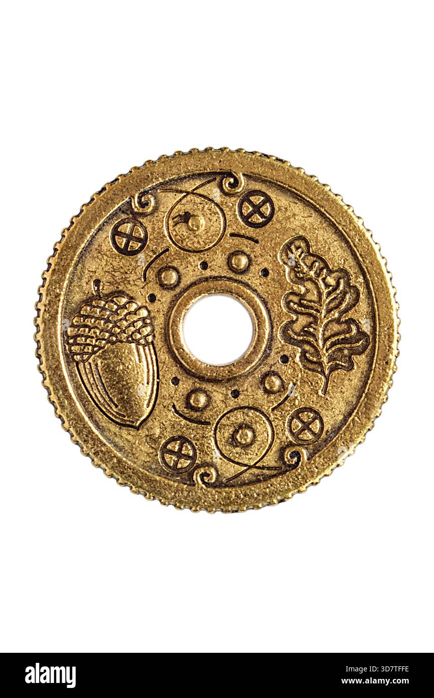 Goldene Souvenirmünze mit Glücksbringer isoliert auf weißem Hintergrund Stockfoto