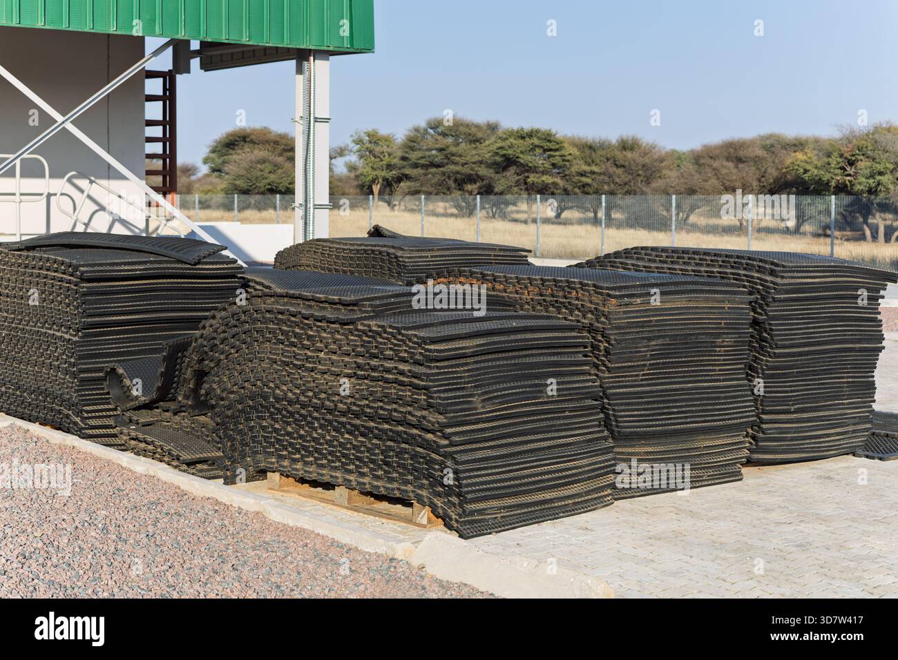 Stapel von industriellen Sicherheitsmatten aus schwarzem Gummi, EPDM, Neopren und EVA, die auf Paletten außerhalb eines Lagers gelagert werden. Strapazierfähiger, robuster Bodenbelag Stockfoto
