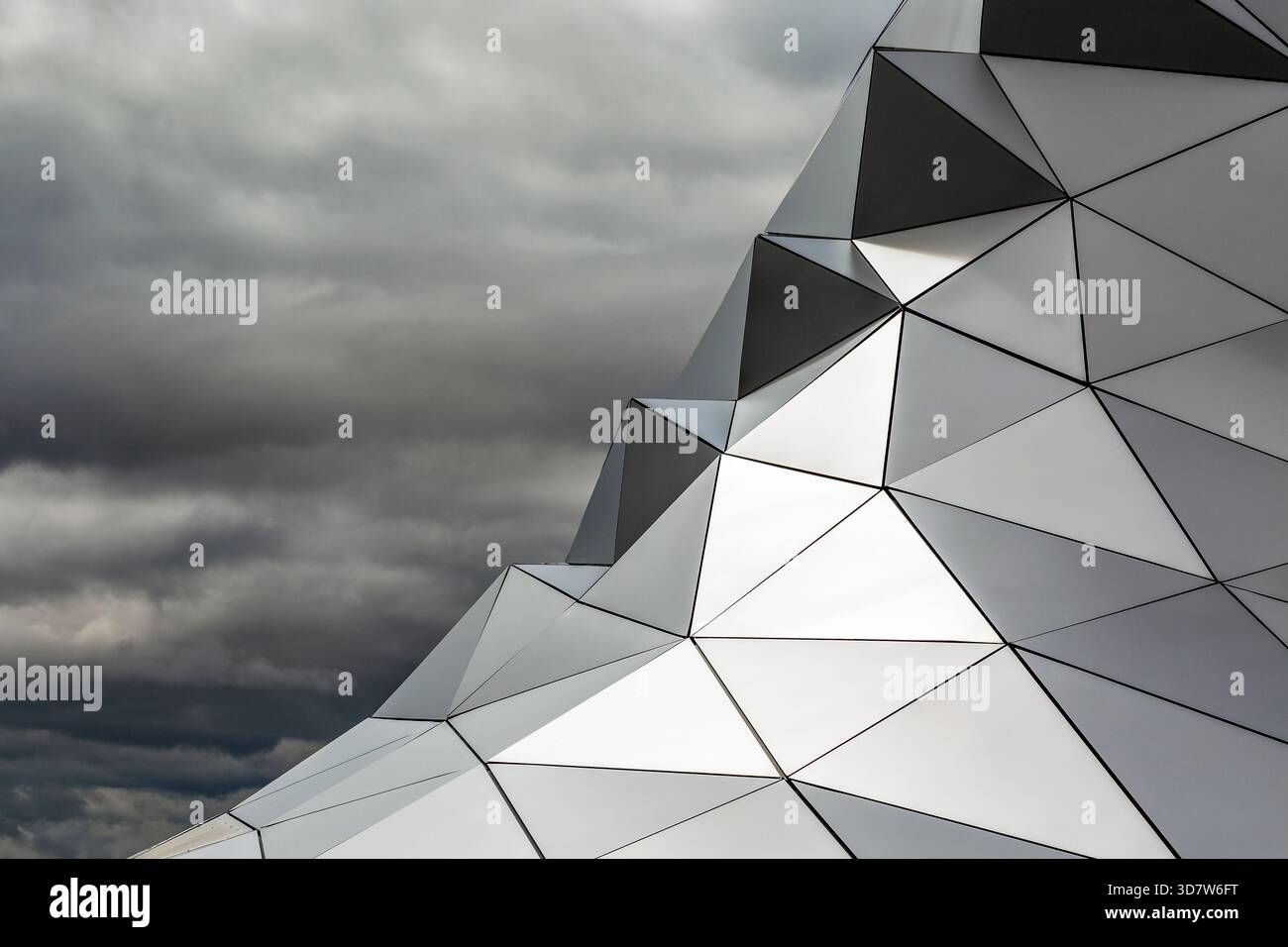 Geometrische Metallstruktur mit scharfen Winkeln gegen bewölkten Himmel. Lyon, Frankreich Stockfoto