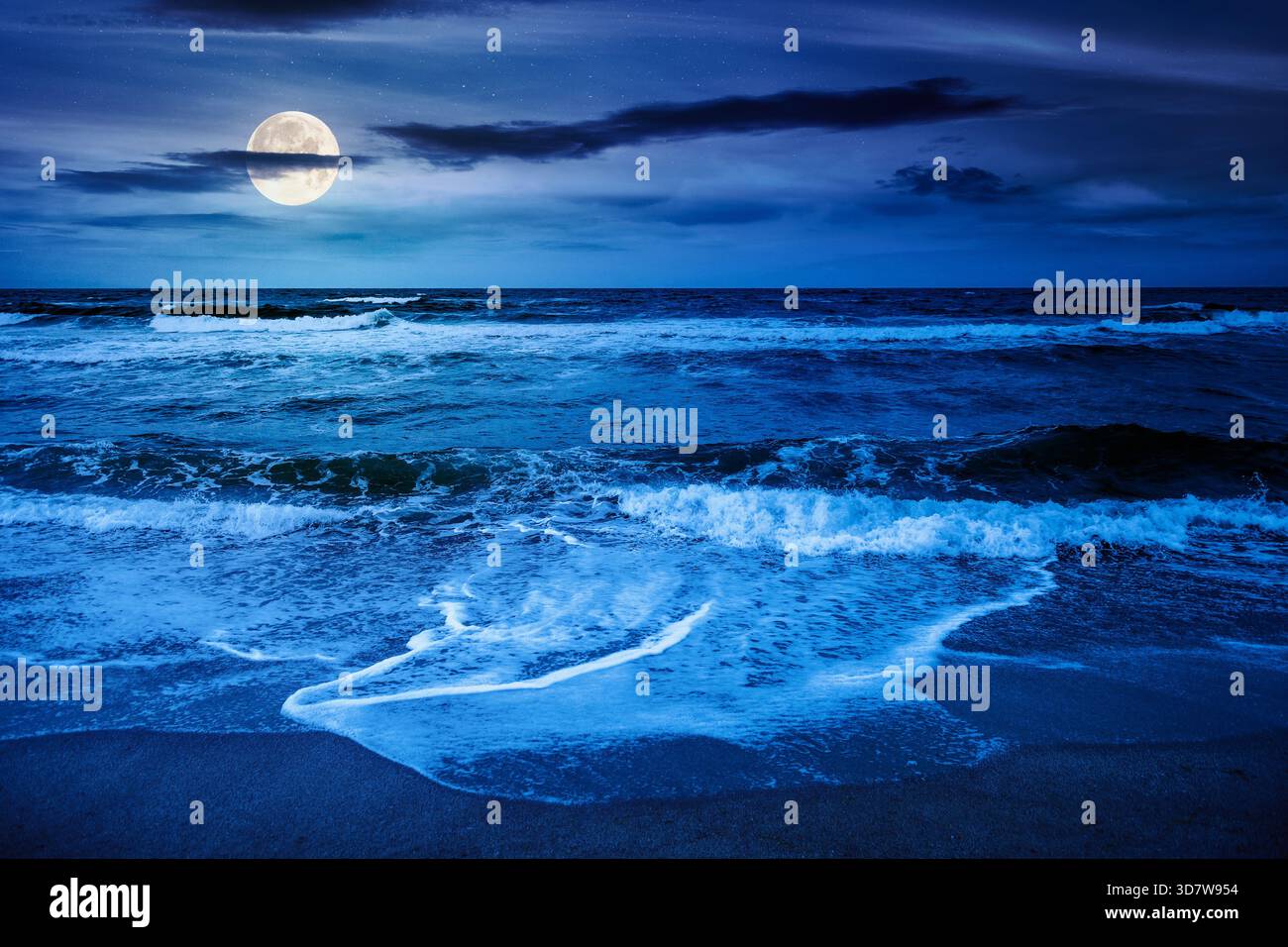Schwarze Meereswellen stürzen nachts am Sandstrand. Sommerurlaub bei windigem Wetter unter dunklem bewölktem Himmel bei Vollmondlicht. Blick auf die dramatische Meereslandschaft. Stockfoto