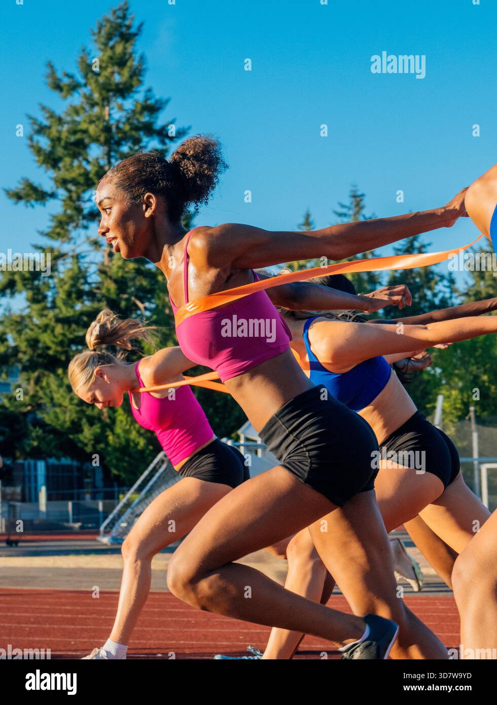 Frauen sprinten tagsüber auf einer Outdoor-Strecke unter klarem blauem Himmel. WA, USA Stockfoto