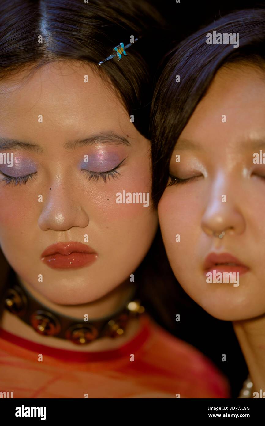 Zwei Frauen mit Pastelllidschatten und geschlossenen Augen, eine mit Choker und Haarspange. Shanghai, China Stockfoto