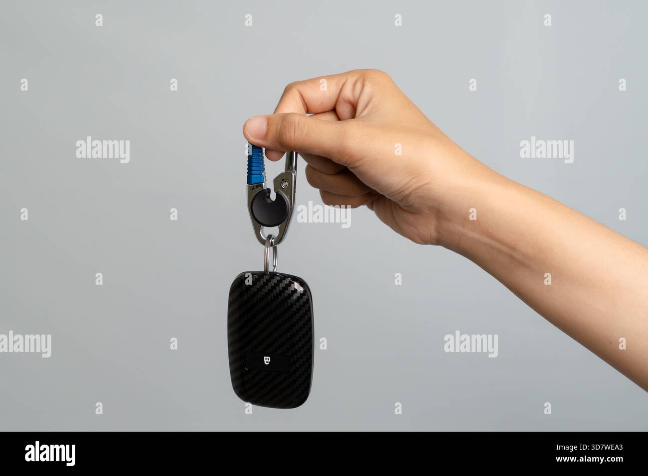 Hand mit Einem modernen Autoschlüssel-Griffstück mit Kohlefaser-Design Stockfoto