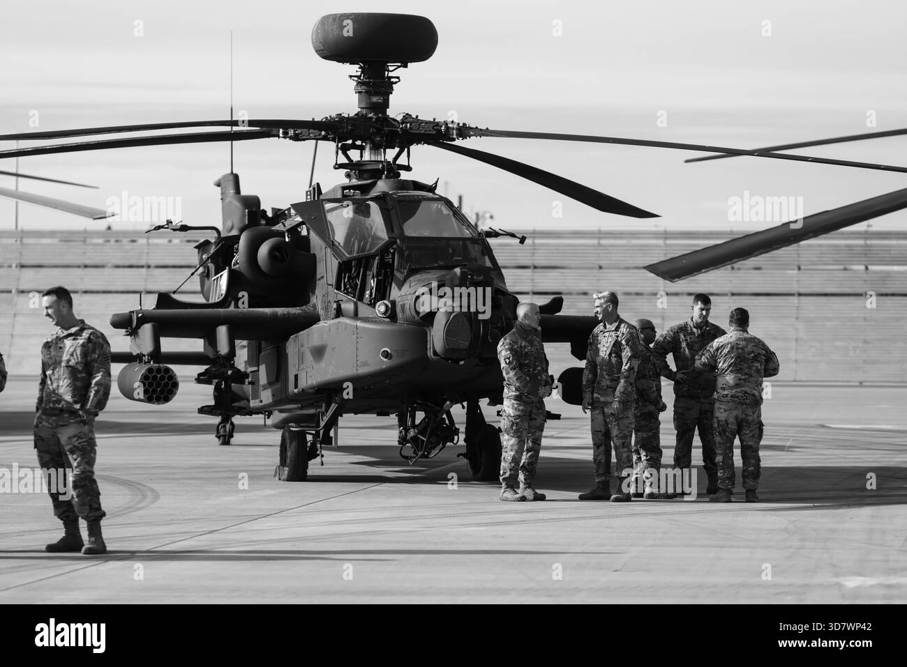 Mihail Kogalniceanu, Rumänien - 25. November 2025: US-Militärsoldat in der Nähe eines Hughes/McDonnell Douglas/Boeing AH-64 Apache Militärhubschraubers. Stockfoto