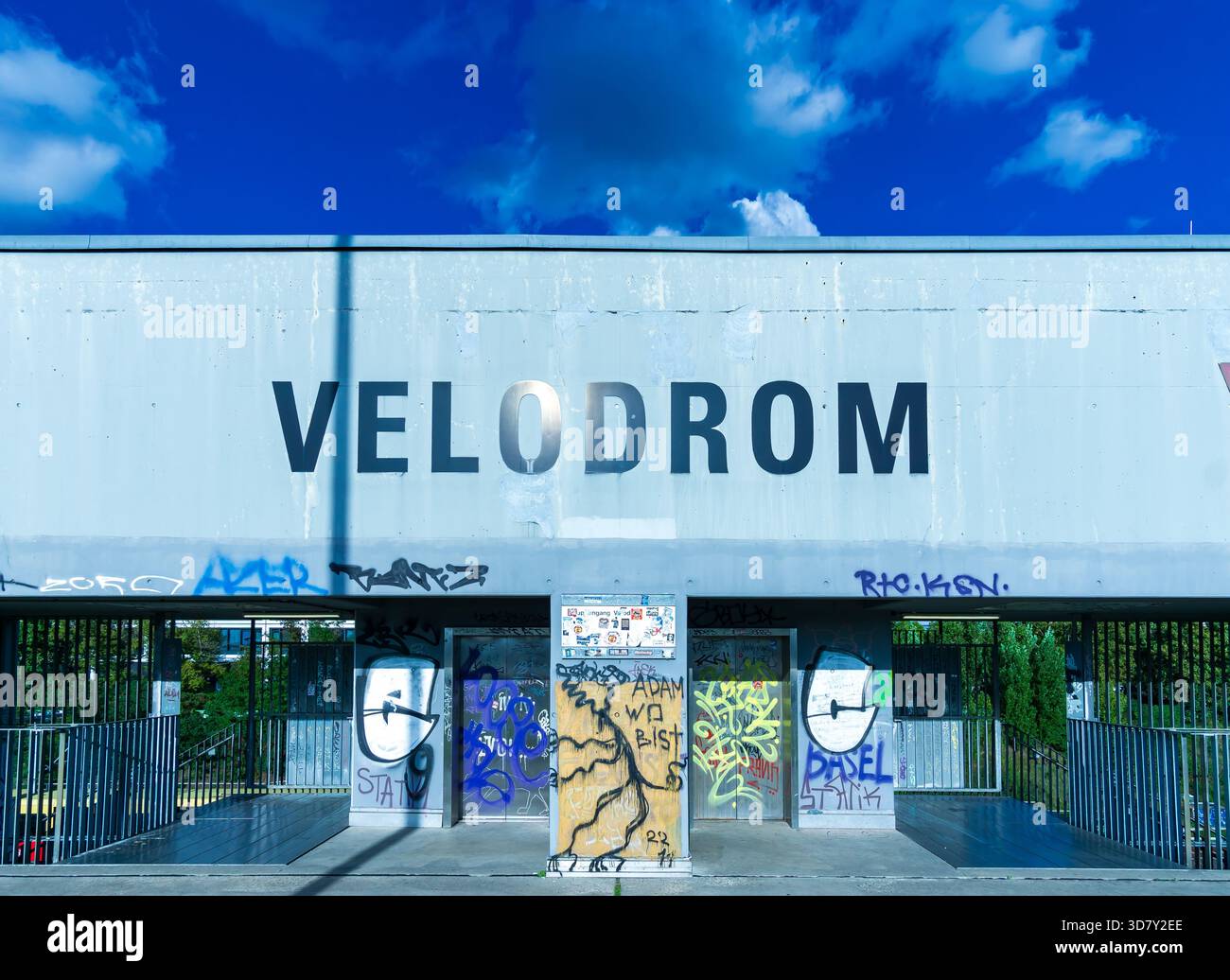 Nahaufnahme des Velodrom-Eingangs in Berlin mit Schwerpunkt auf der großen Fassadenbeschriftung und umgebenden Graffiti. Stockfoto
