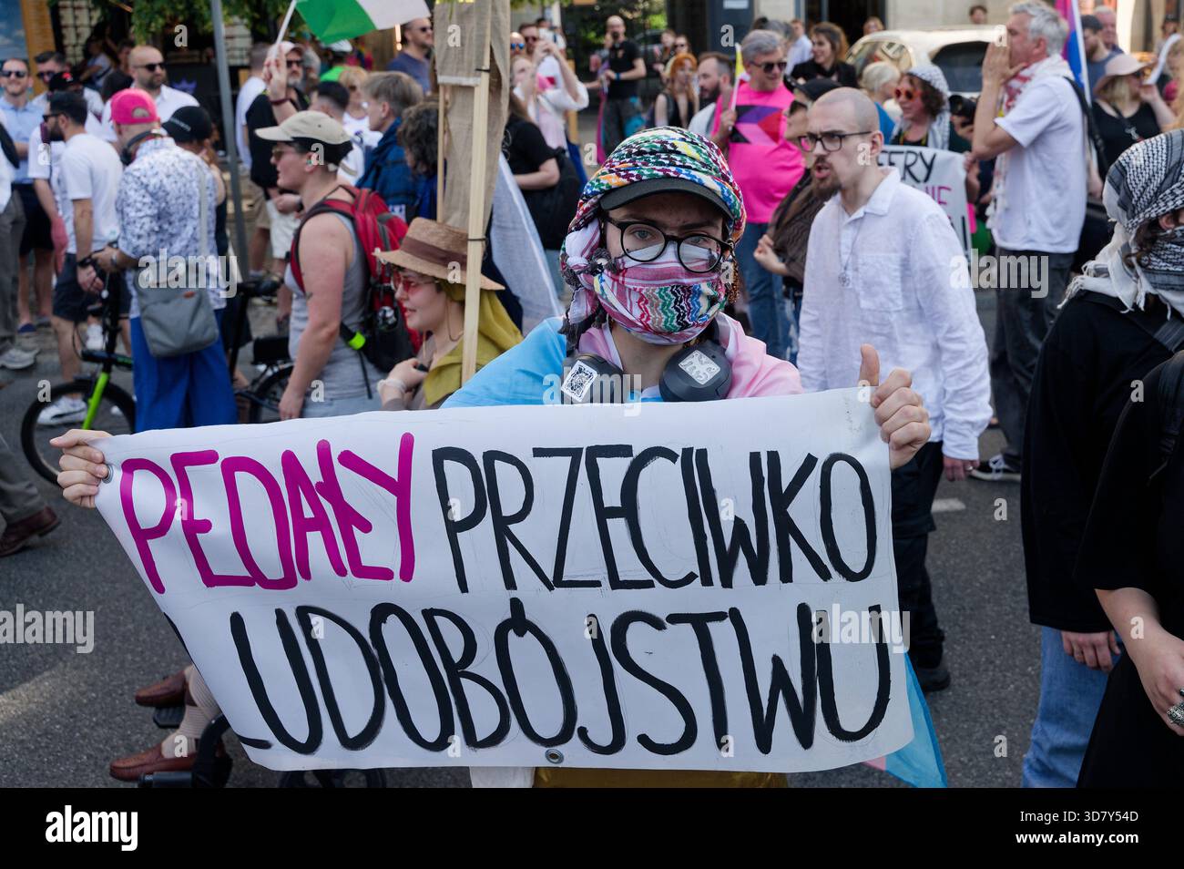Der Protestteilnehmer hält ein handgeschriebenes Schild, während er während des Warschauer Pride (Parada Równości) unter einer großen Menschenmenge steht. Stockfoto
