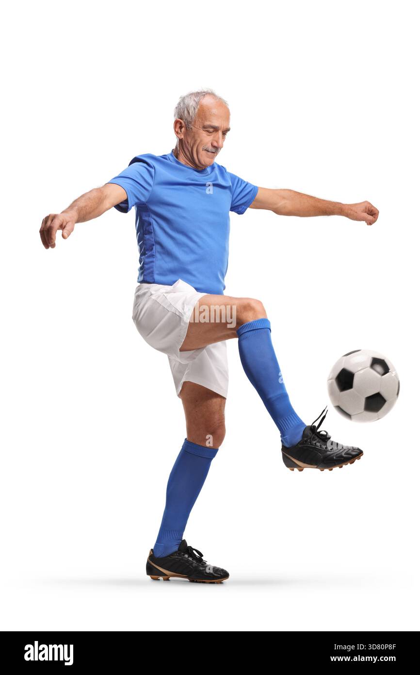 Älterer Fußballspieler, der einen Ball isoliert auf weißem Hintergrund tritt Stockfoto