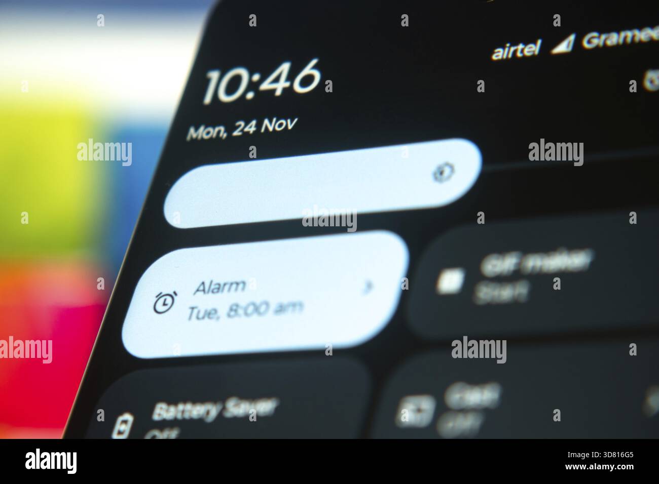 Smartphone-Bildschirm, der Uhrzeit und Datum anzeigt und einen Alarm auf 8:00 Uhr eingestellt hat, wobei eine digitale Schnittstelle hervorgehoben wird Stockfoto