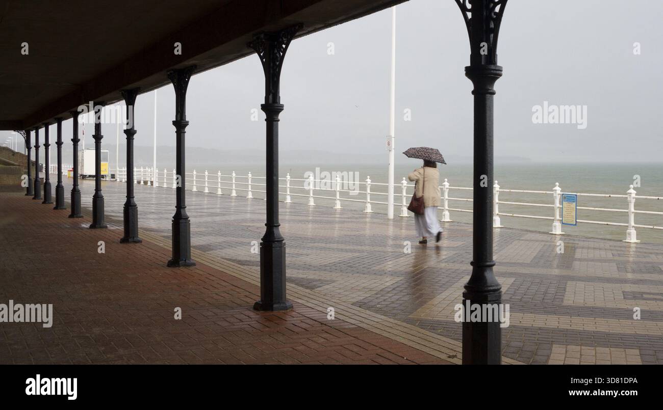 Bridlington, England, 10. August: Eine Frau, die auf der Promenade spaziert, während stürmisches Wetter über die Küste stürmt 10. August: 2014 Bridlington, England Stockfoto
