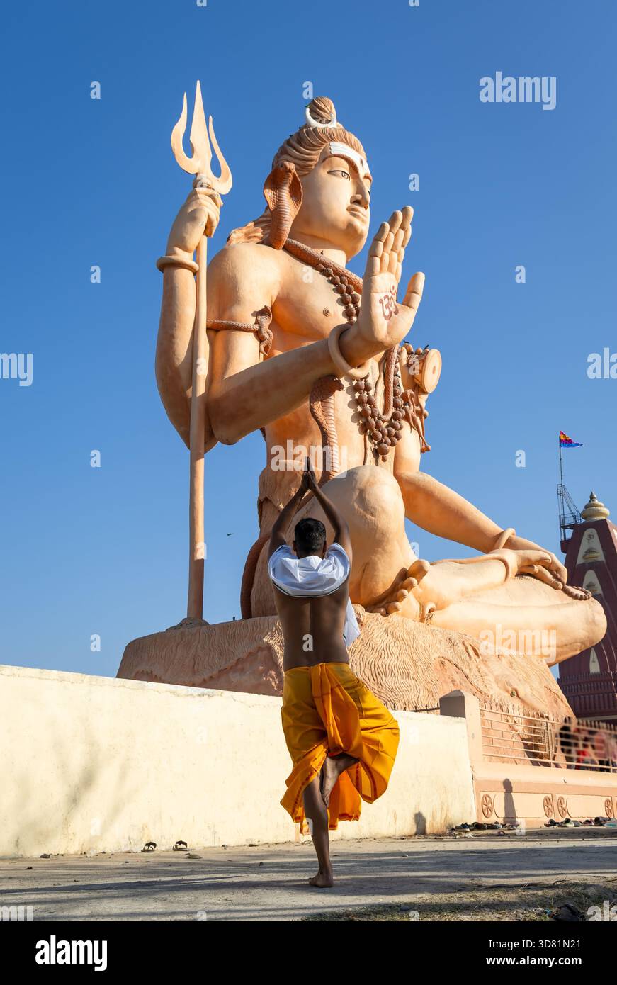 Treuer Pilger, der vor Herrn shiva salutiert, mit Blick auf den blauen Himmel Stockfoto