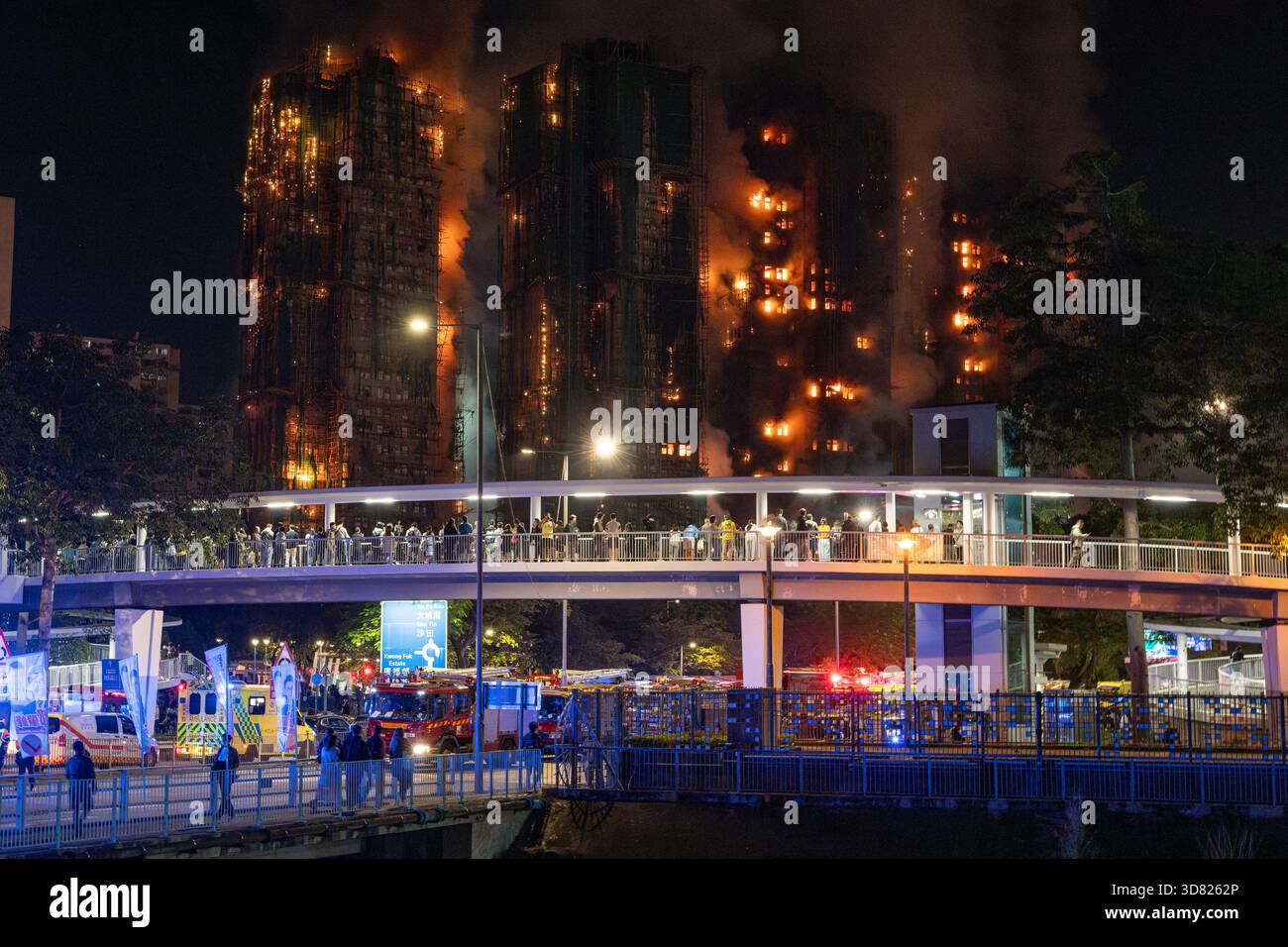 Am 26. November 2025 brach Ein Feuer im Wohnkomplex Wang Fuk Court im Tai Po District, New Territories, Hongkong aus. Viele Menschen standen auf der Brücke und beobachteten das Feuer des Hong Kong Tower. Der Brand wurde als Brand mit fünf Alarmen eingestuft, die örtlichen Behörden haben mindestens 83 Tote (einschließlich eines Feuerwehrmannes), 77 Verletzte und Hunderte von Vermissten gemeldet. Die Brandursache wird noch untersucht. Dieses Foto wurde an der Tai Po Road aufgenommen. Es war taffische Marmelade wegen des Unfalls. (Foto: Cheng Wai Hok/SIPA USA) Stockfoto