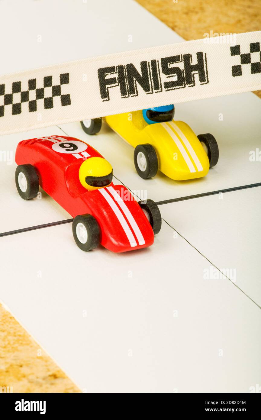 Spielzeugautos fahren, wobei einer die Ziellinie überquert Stockfoto