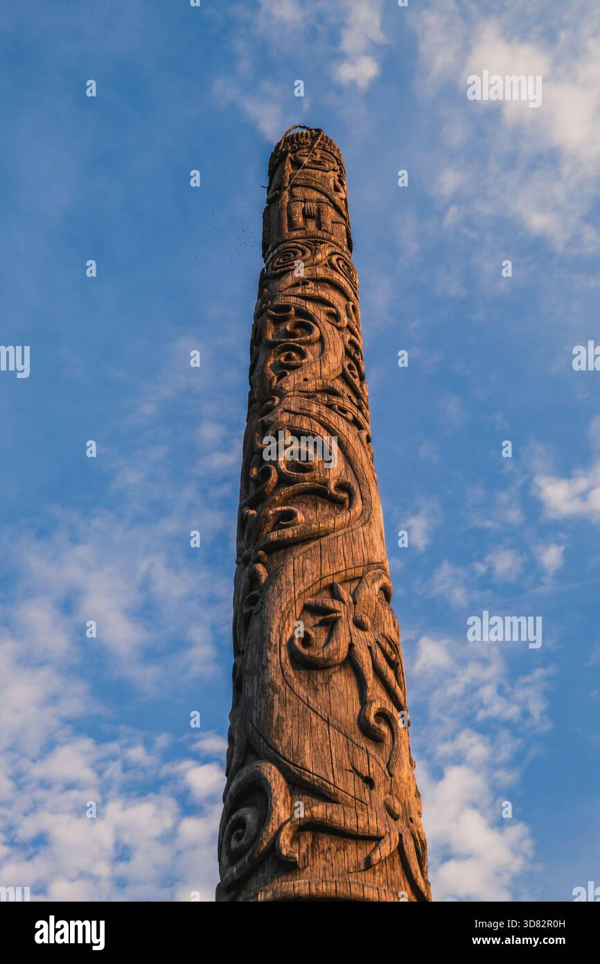 West Kutai, Indonesien – am 10. Oktober 2025 steht Ein traditioneller Dayak-Holzpfahl mit aufwändigen Schnitzereien hoch unter klarem Himmel. Stockfoto