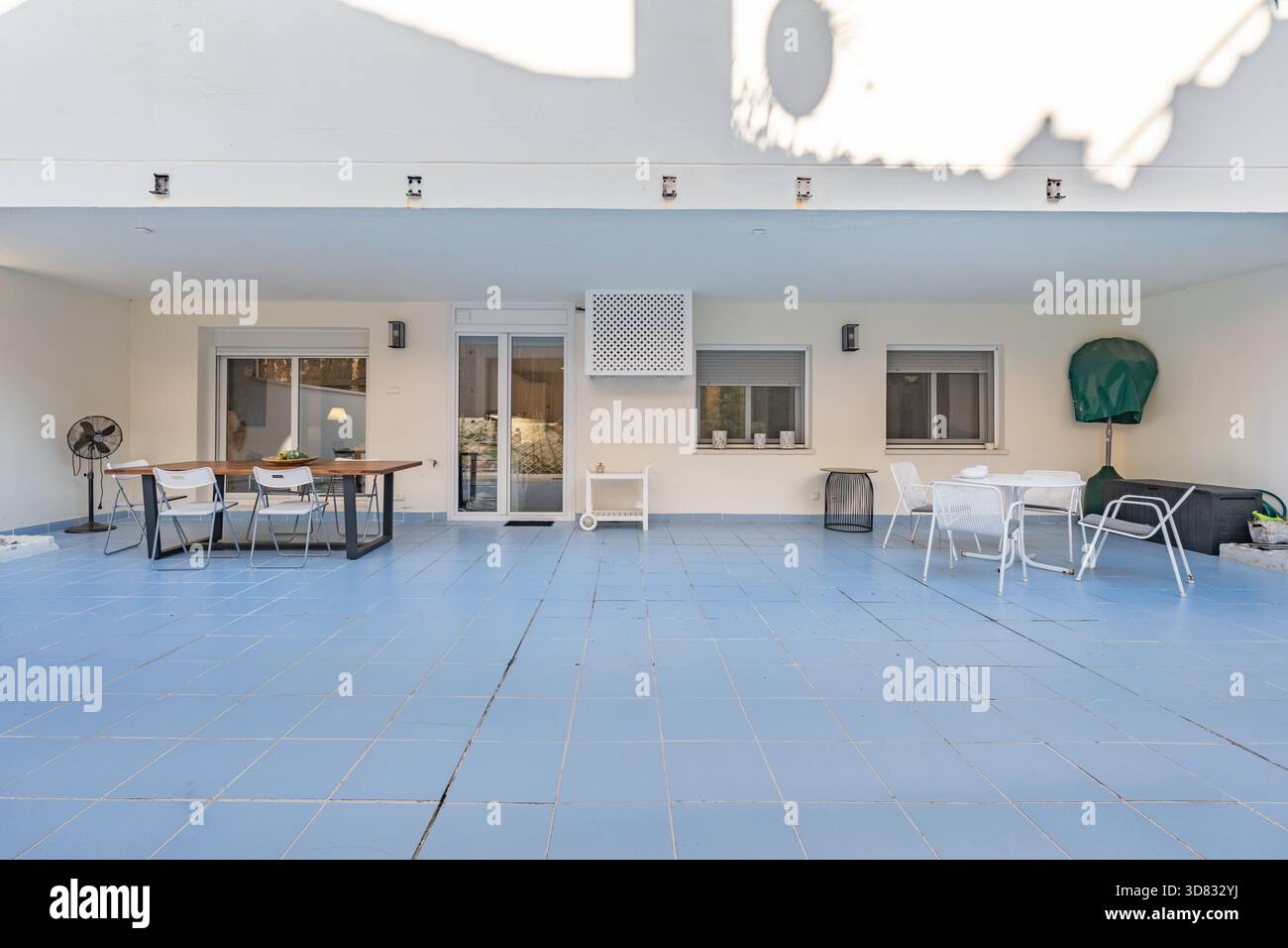 Terrasse im mediterranen Apartment mit Essbereich und blauem Fliesenboden Stockfoto