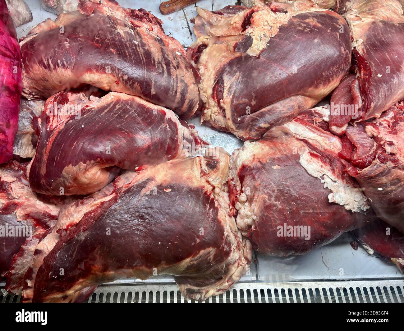 Nahaufnahme von frischen, rohen Stücken von rotem Fleisch mit Fett in einem Metzgerstand Stockfoto
