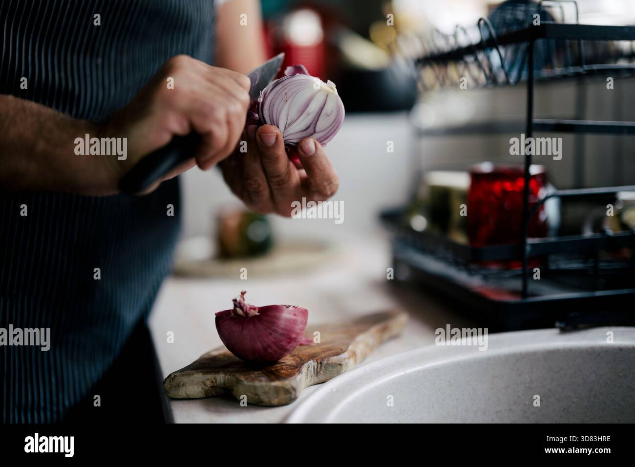 Zubereitung mit roten Zwiebelschnitten in einer gemütlichen Küche Stockfoto