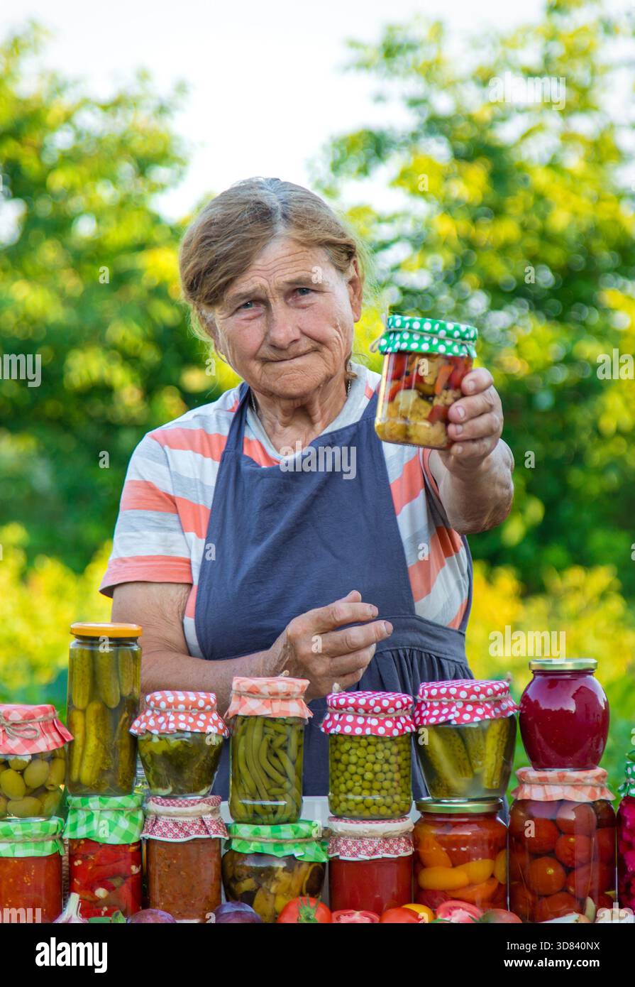 Ältere Frau, die Gemüse in Gläsern konservieren. Selektiver Fokus. Essen. Stockfoto