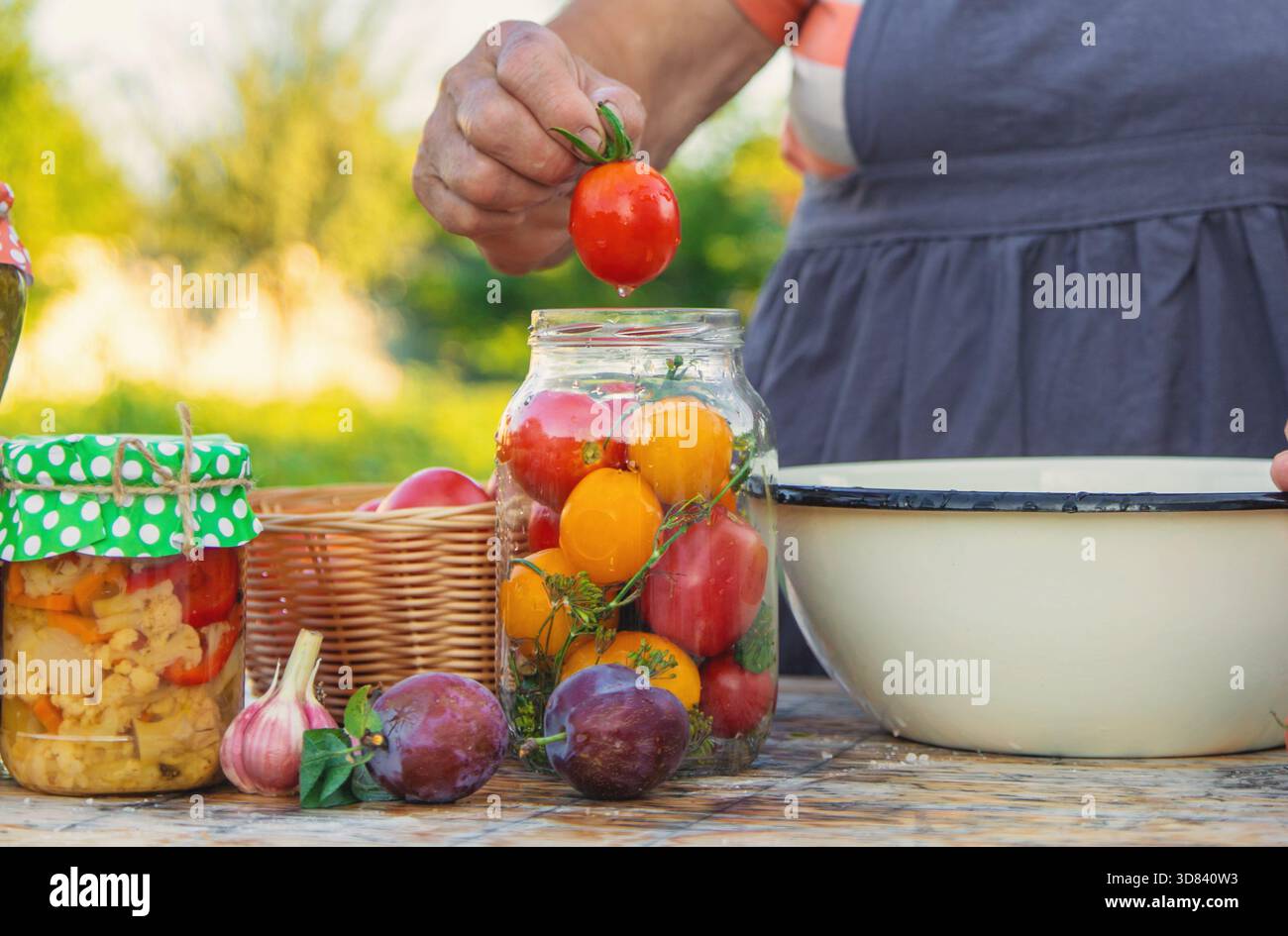 Ältere Frau, die Gemüse in Gläsern konservieren. Selektiver Fokus. Essen. Stockfoto