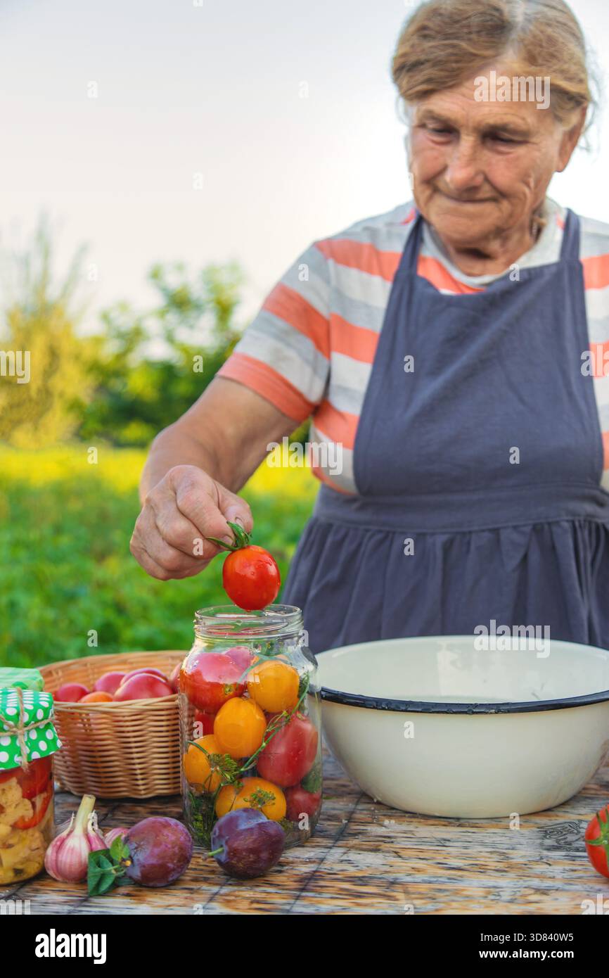 Ältere Frau, die Gemüse in Gläsern konservieren. Selektiver Fokus. Essen. Stockfoto