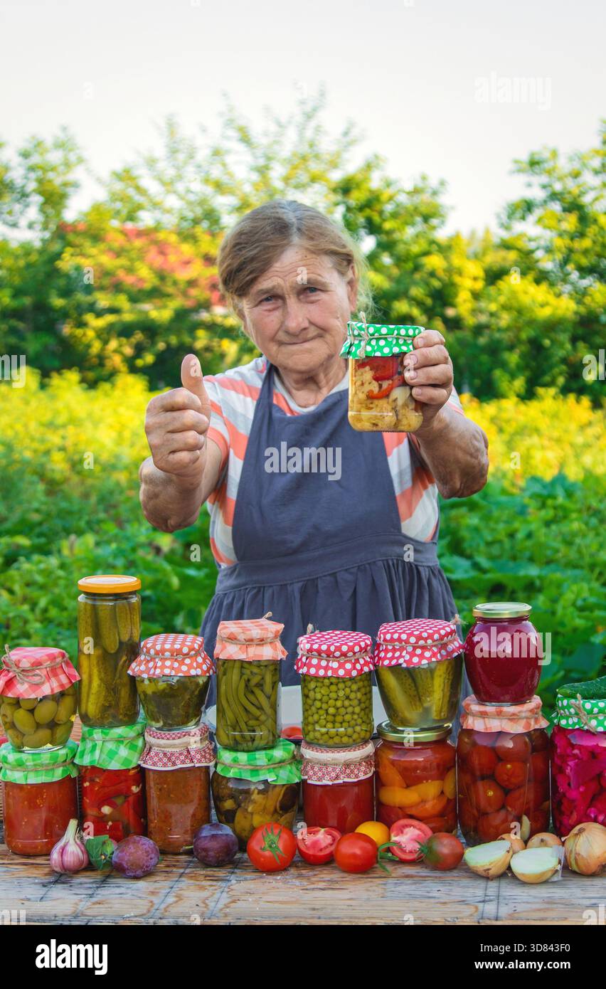 Ältere Frau, die Gemüse in Gläsern konservieren. Selektiver Fokus. Essen. Stockfoto