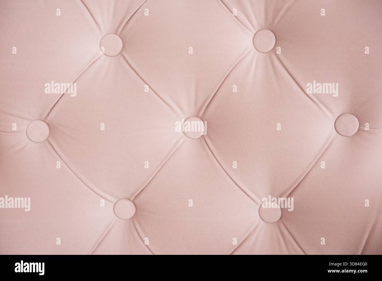 Die Oberfläche des Sofas in Nahaufnahme. Der Schlittenbinder ist geknöpft. Rosa Chesterfield-Stil gesteppte Polsterung Hintergrund Nahaufnahme Stockfoto