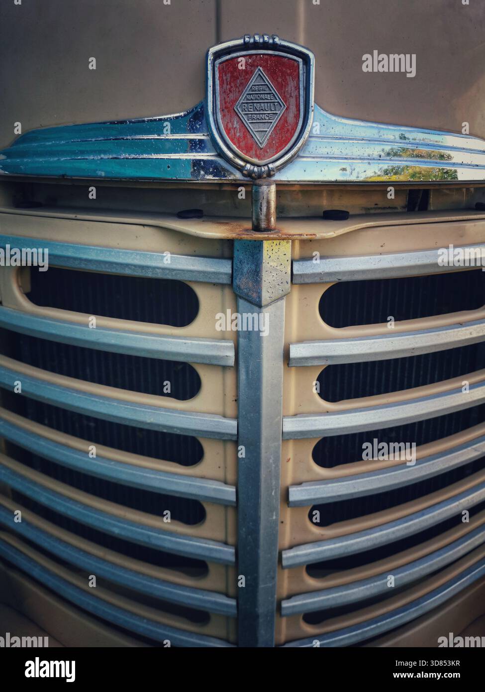Hier sehen Sie den Grill und die Motorhaube eines älteren Renault-Fahrzeugs. Die Vorderseite trägt das Renault Emblem und weist Rost und Verschleiß am Fahrzeug auf Stockfoto