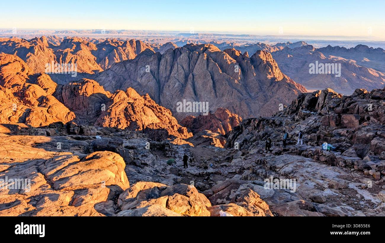 Sonnenlicht über den roten Bergen des Mount Sinai und die stille Schönheit der Wüstengipfel während des Aufstiegs zum Berg Moses Stockfoto
