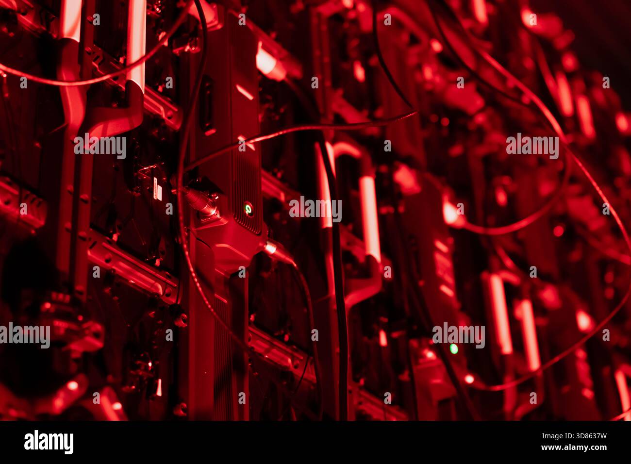 Großes Raster vertikal ausgerichteter Hardwarekomponenten mit umfangreicher Verkabelung und kleinen beleuchteten Punkten, die eine dicht gepackte elektronische Struktur bilden Stockfoto