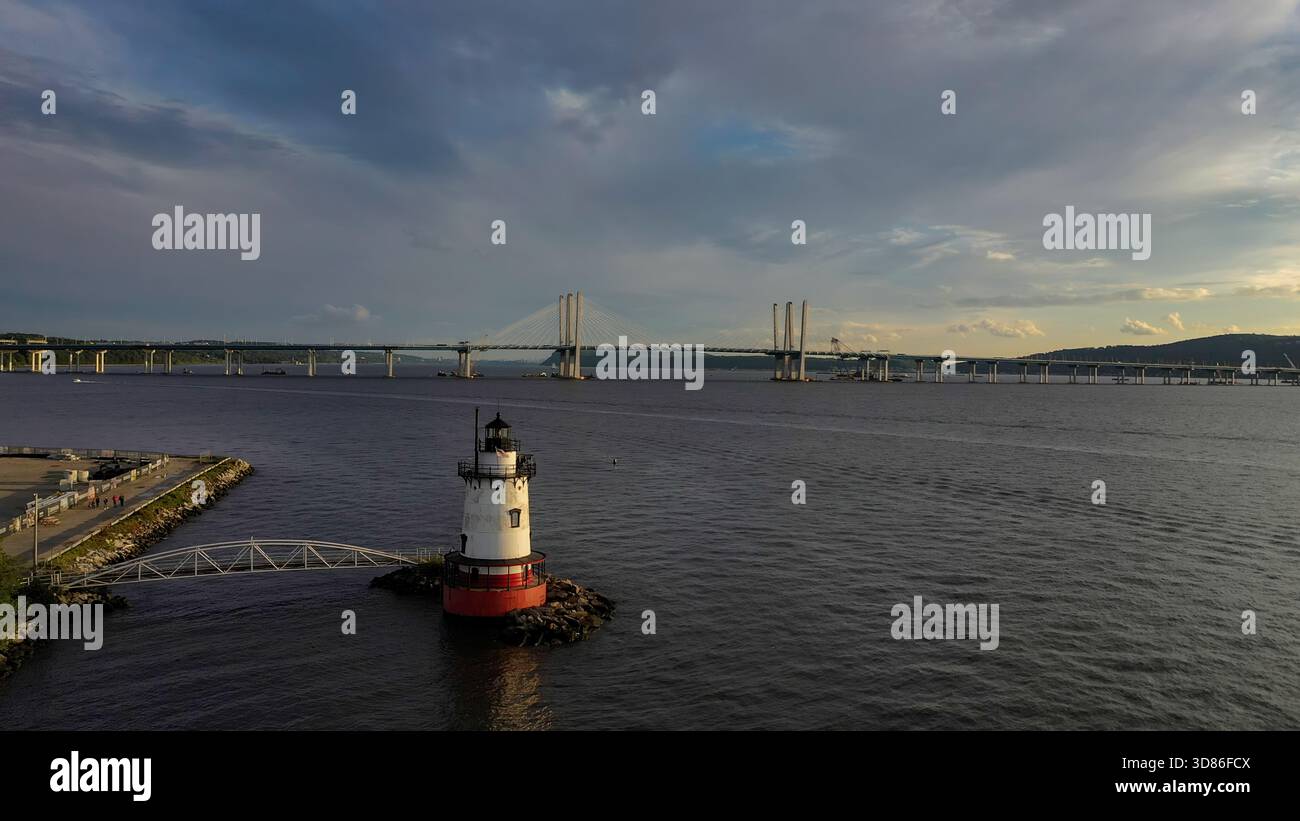Aus der Vogelperspektive eines Leuchtturms, der auf der Wache steht, während sich die Gouverneur Mario M. Cuomo Bridge über den Hudson River unter einem dramatischen Himmel erstreckt, Tarrytown, ne Stockfoto