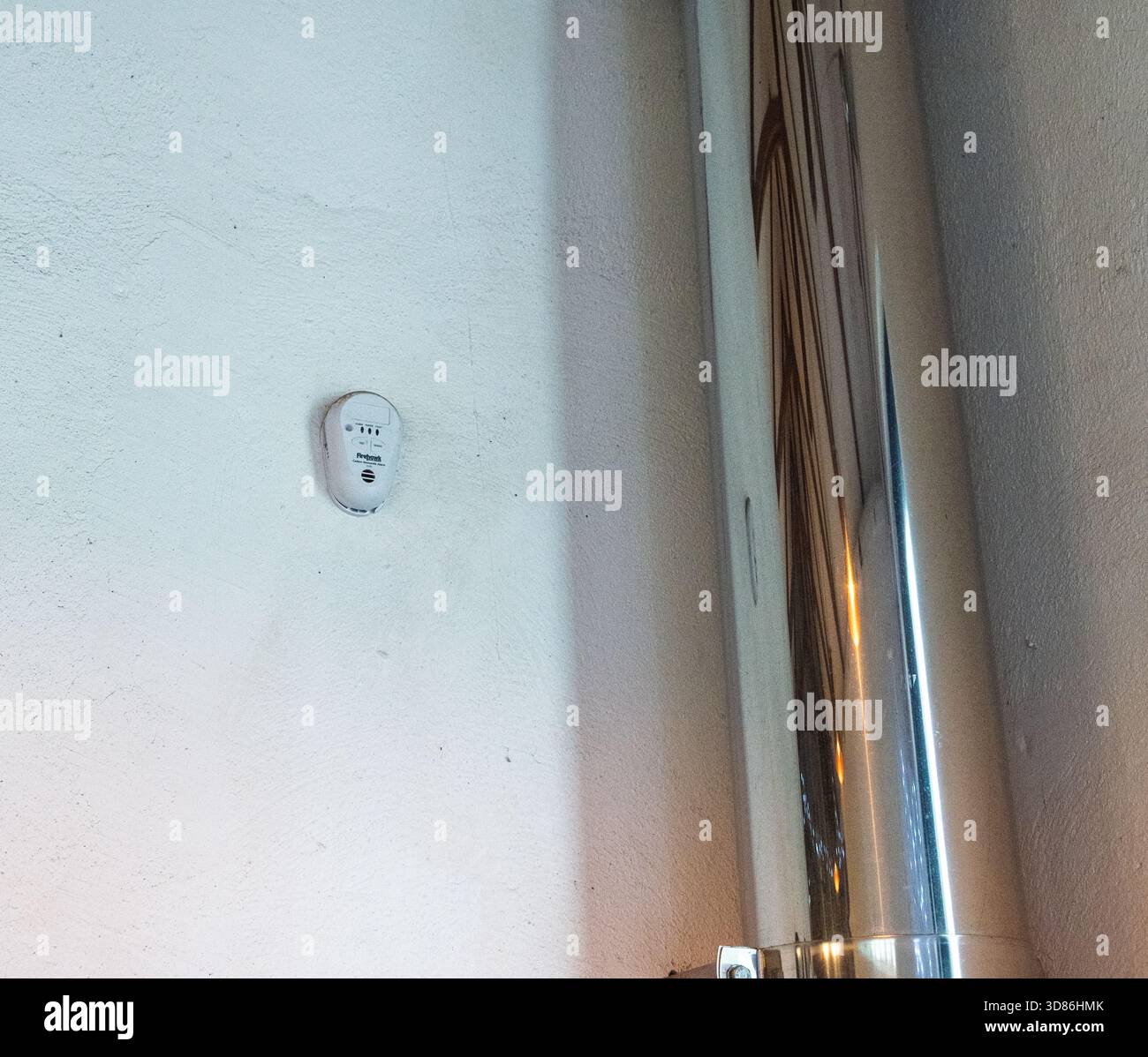 Ein Firehawk-Kohlenmonoxid-Alarm, der zu nahe an einem Rauchrohr für einen Holzofen montiert ist. Nicht korrekt installiert, sollte ein Abstand von 1 bis 3 m eingehalten werden Stockfoto