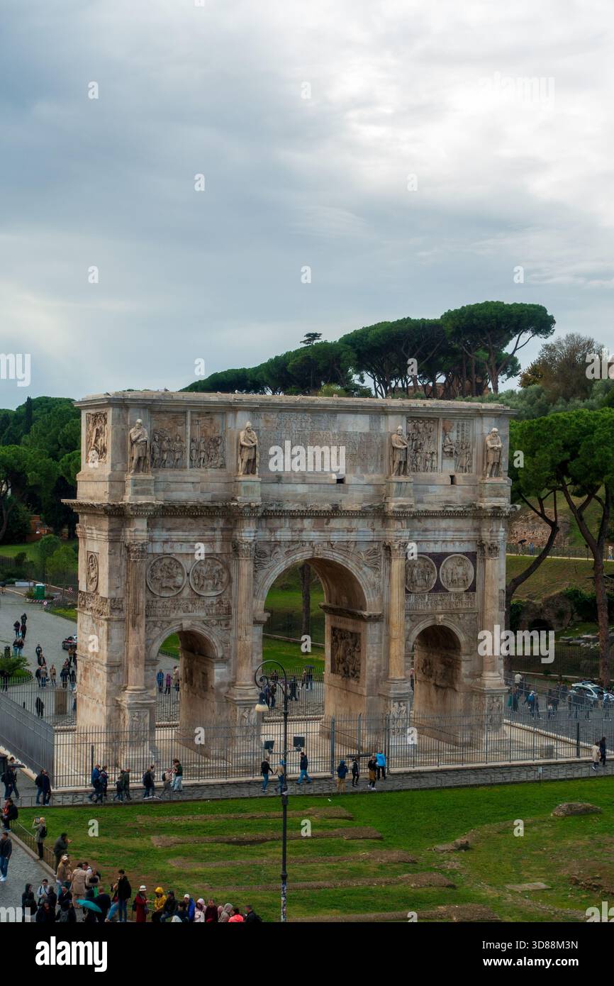 Touristen besuchen den Konstantinsbogen in Rom, Italien, um seine historische Bedeutung und architektonische Schönheit zu bewundern. Stockfoto