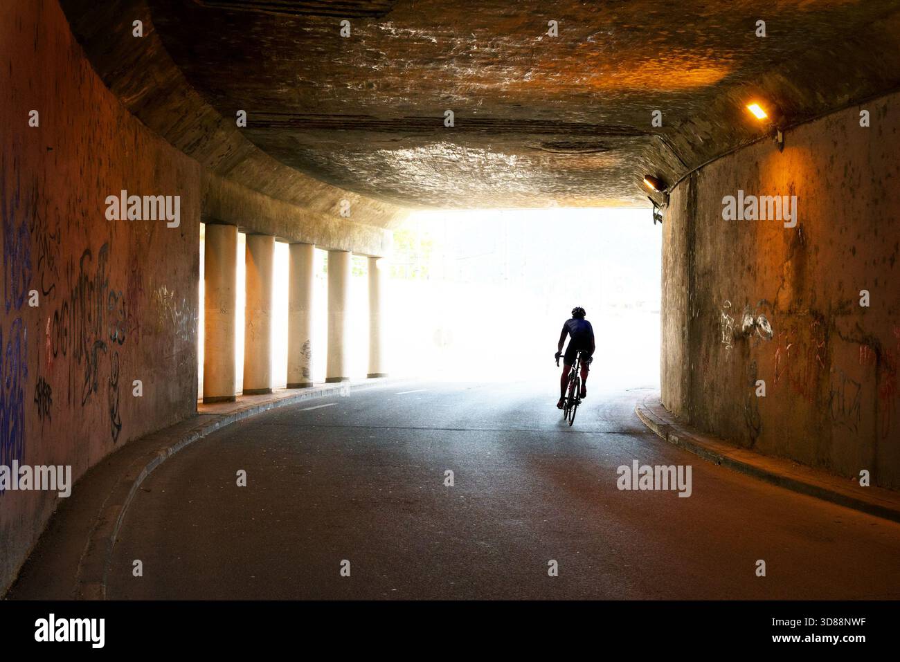 Silhouette einer Person, die in einem Tunnel Fahrrad fährt Stockfoto