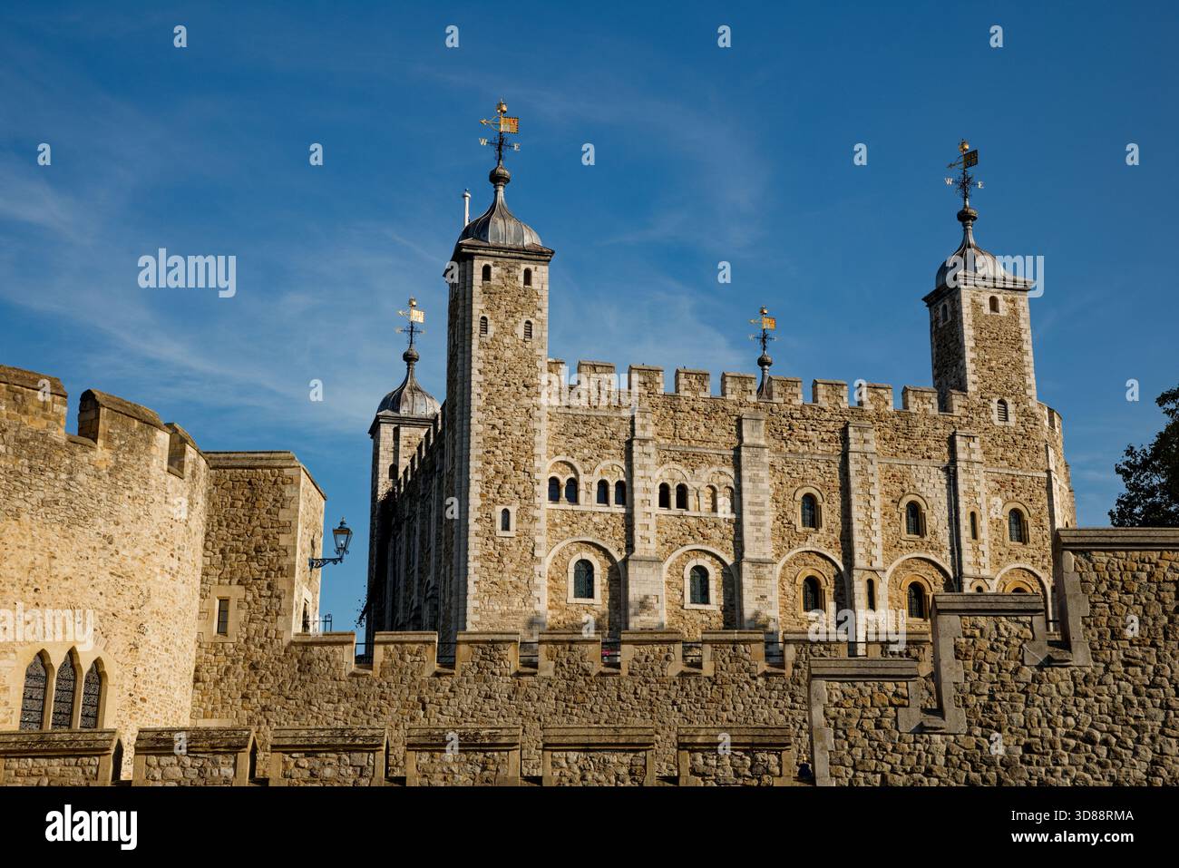 Der berühmte White Tower of the Tower of London erhebt sich über den Geflechten der Ringmauer in einen blauen Himmel, City of London, England. Stockfoto