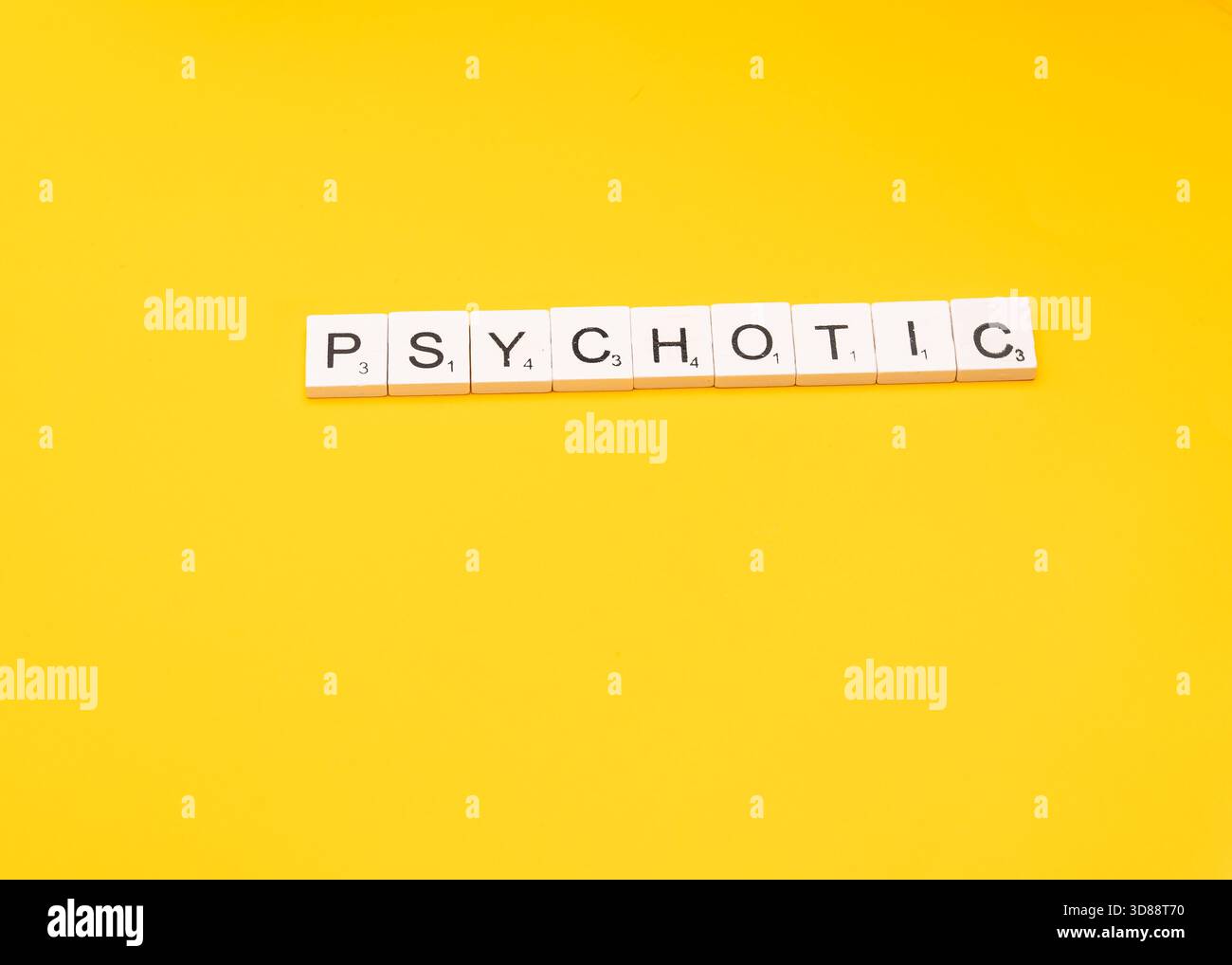 Das Wort „PSYCHOTISCH“ wurde mit Wortkacheln auf hellgelbem Hintergrund geschrieben. Stockfoto