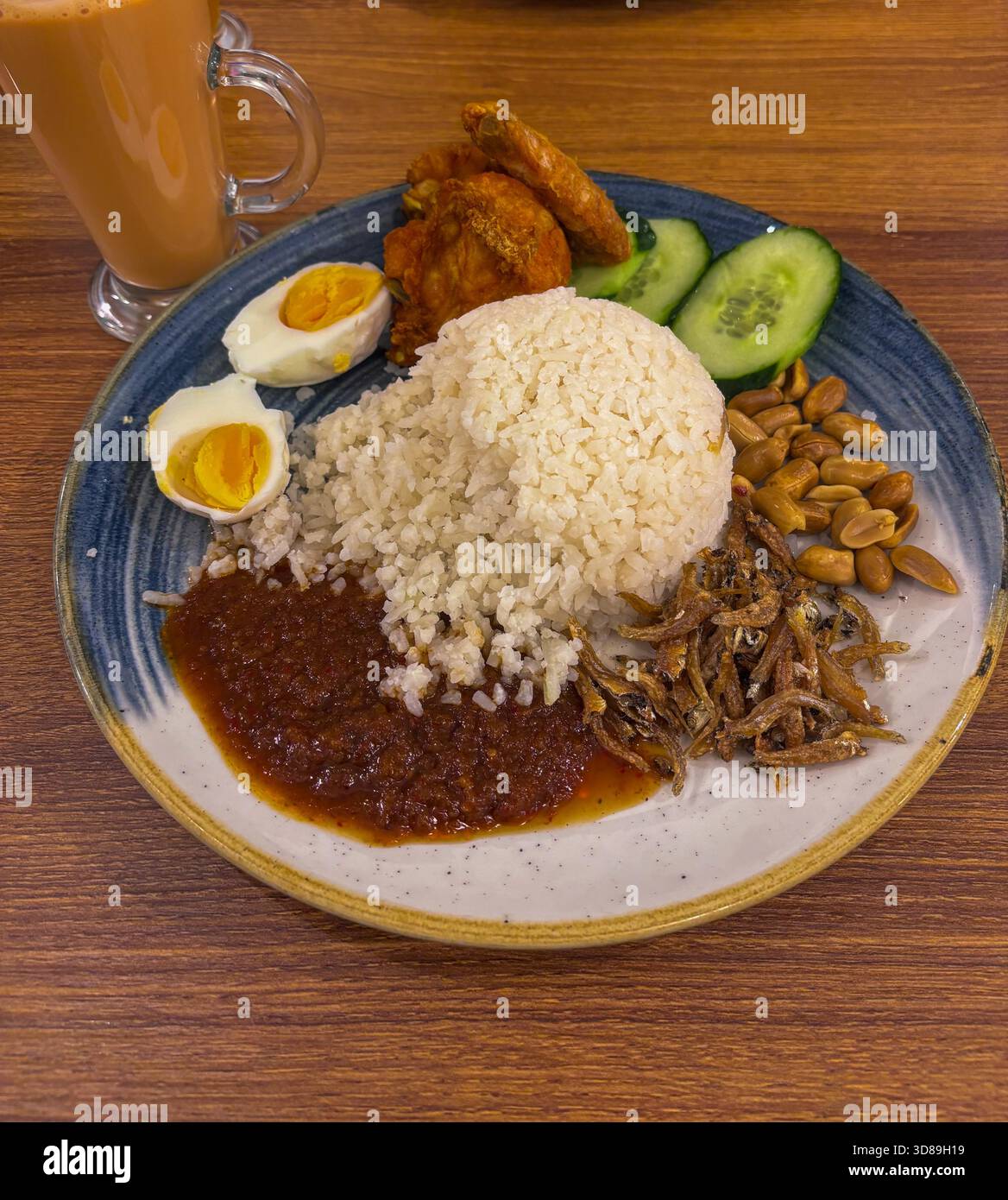 Traditionelles malaysisches Nasi-Lemak-Gericht mit Reis, Sambal, gebratenem Huhn, getrockneten Sardellen und gesalzenem Ei Stockfoto