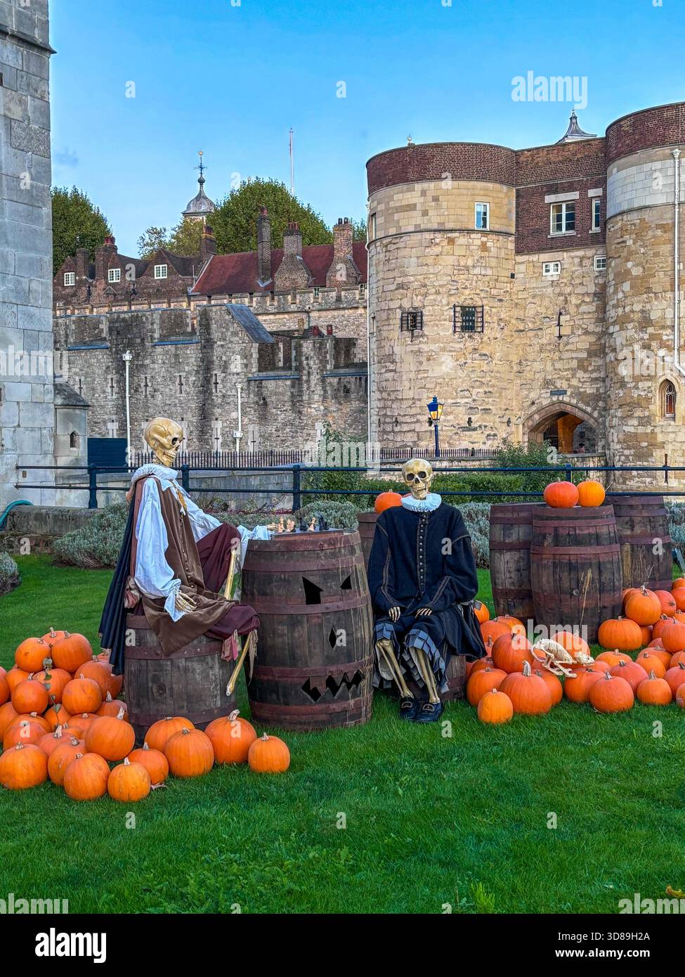 Halloween-Ausstellung mit kostümierten Skeletten und Kürbissen auf dem Rasen in der Nähe des Tower of London Stockfoto