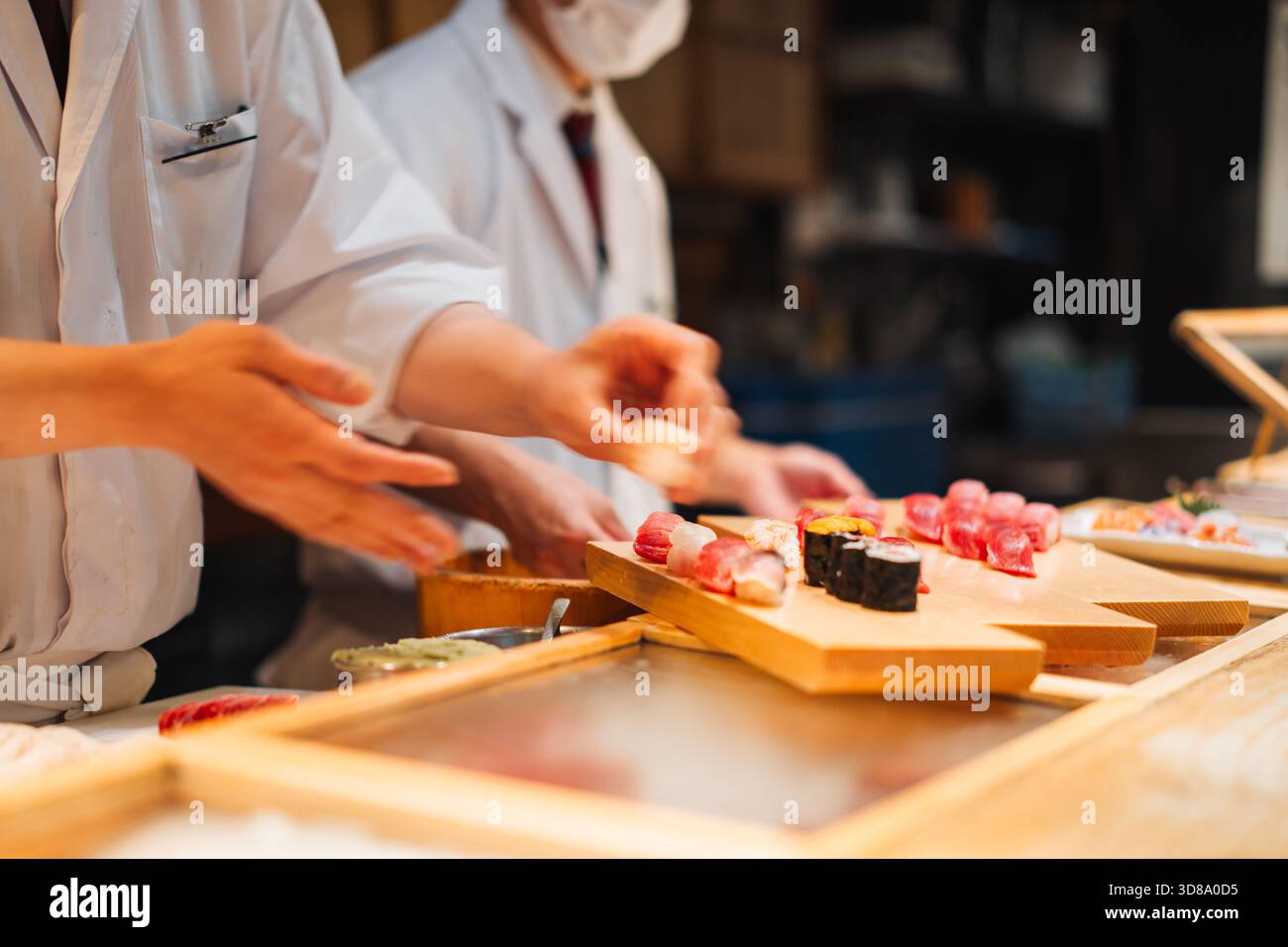 Köche bereiten Sushi für Kunden in einem Restaurant zu Stockfoto