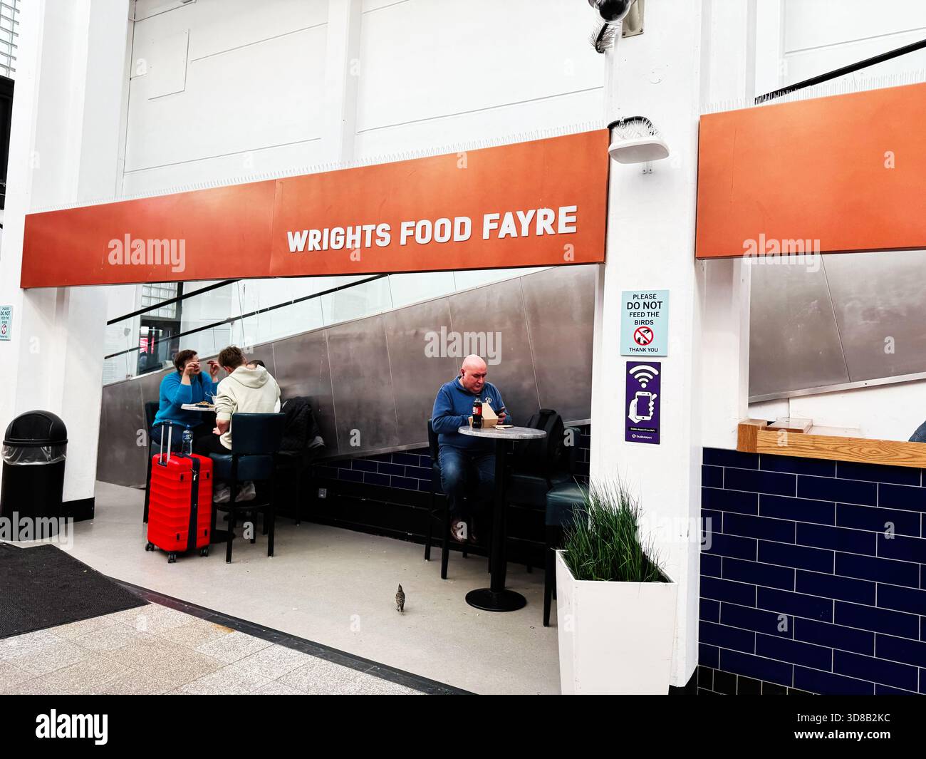 Dublin, Irland - 21. Oktober 2025: Zwangloses Abendessen im Wrights Fayre in Dublin mit Reisenden, Gepäck und modernen Sitzplätzen. Stockfoto