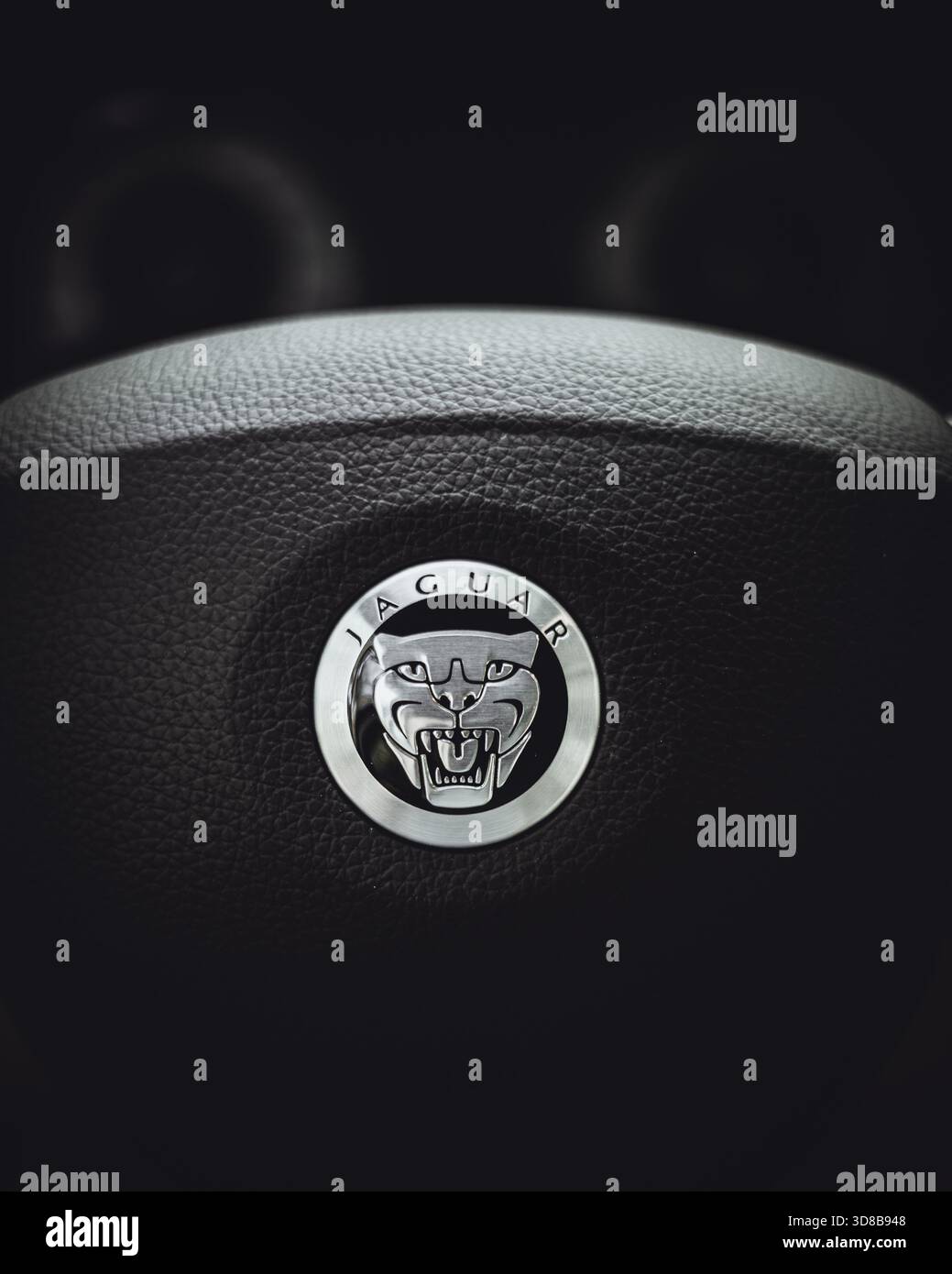 Jaguar Lenkrad mit eingeprägtem Jaguar Logo, Nahaufnahme des Innenraums eines Luxusautos. Stockfoto