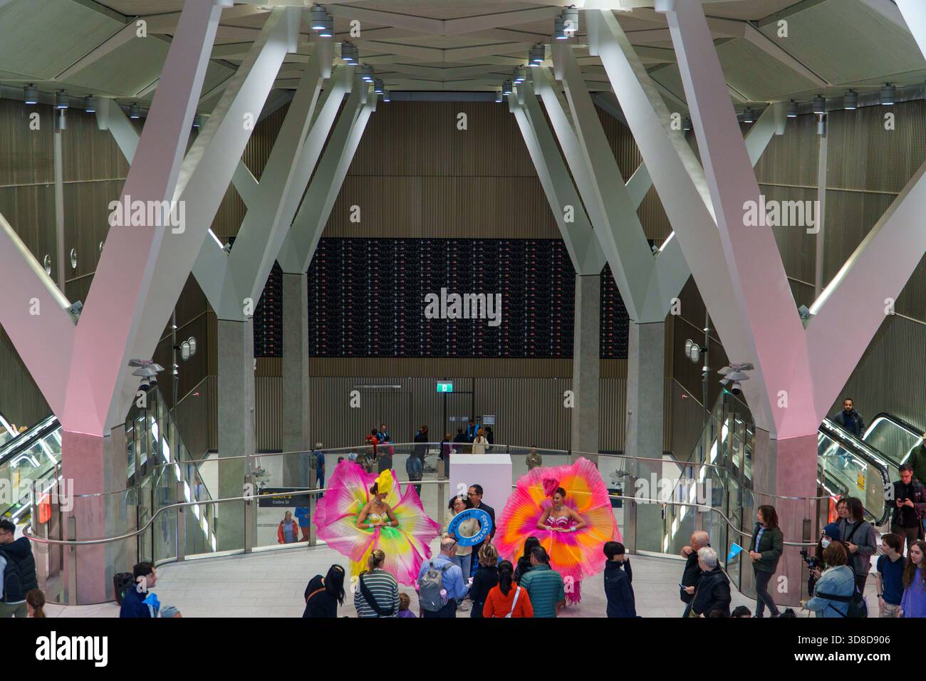 Melbourne, VIC, Australien. 30. November 2025. - Zwei Darsteller in großen, hellen Blumenkostümen feiern den Eröffnungstag des Rathausbahnhofs Stockfoto