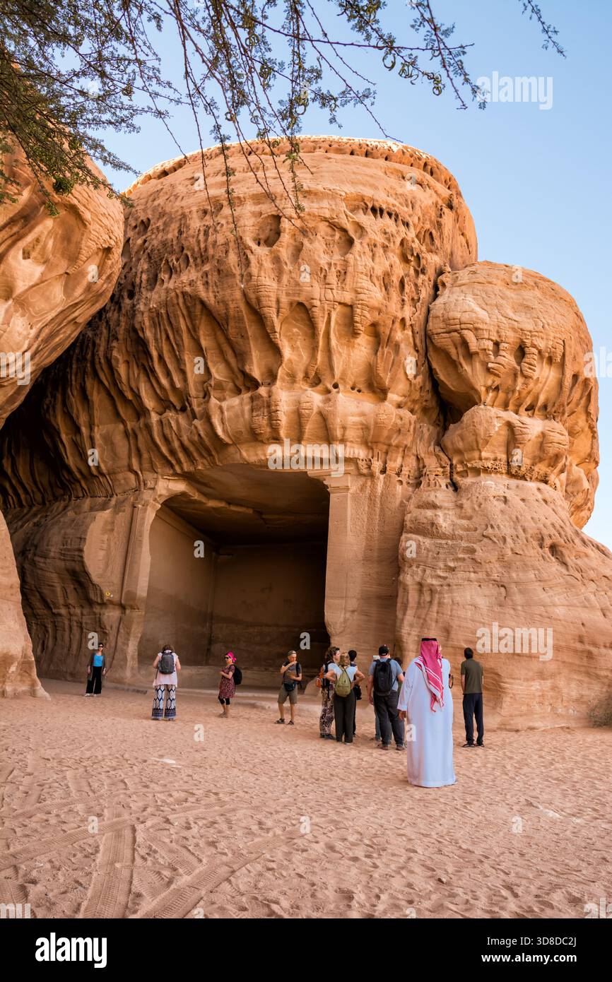 Al Ula, Saudi-Arabien - 23. April 2025: Grabkammer im Sandstein an der historischen Hegra-Stätte in Saudi-Arabien mit Touristen in fr Stockfoto
