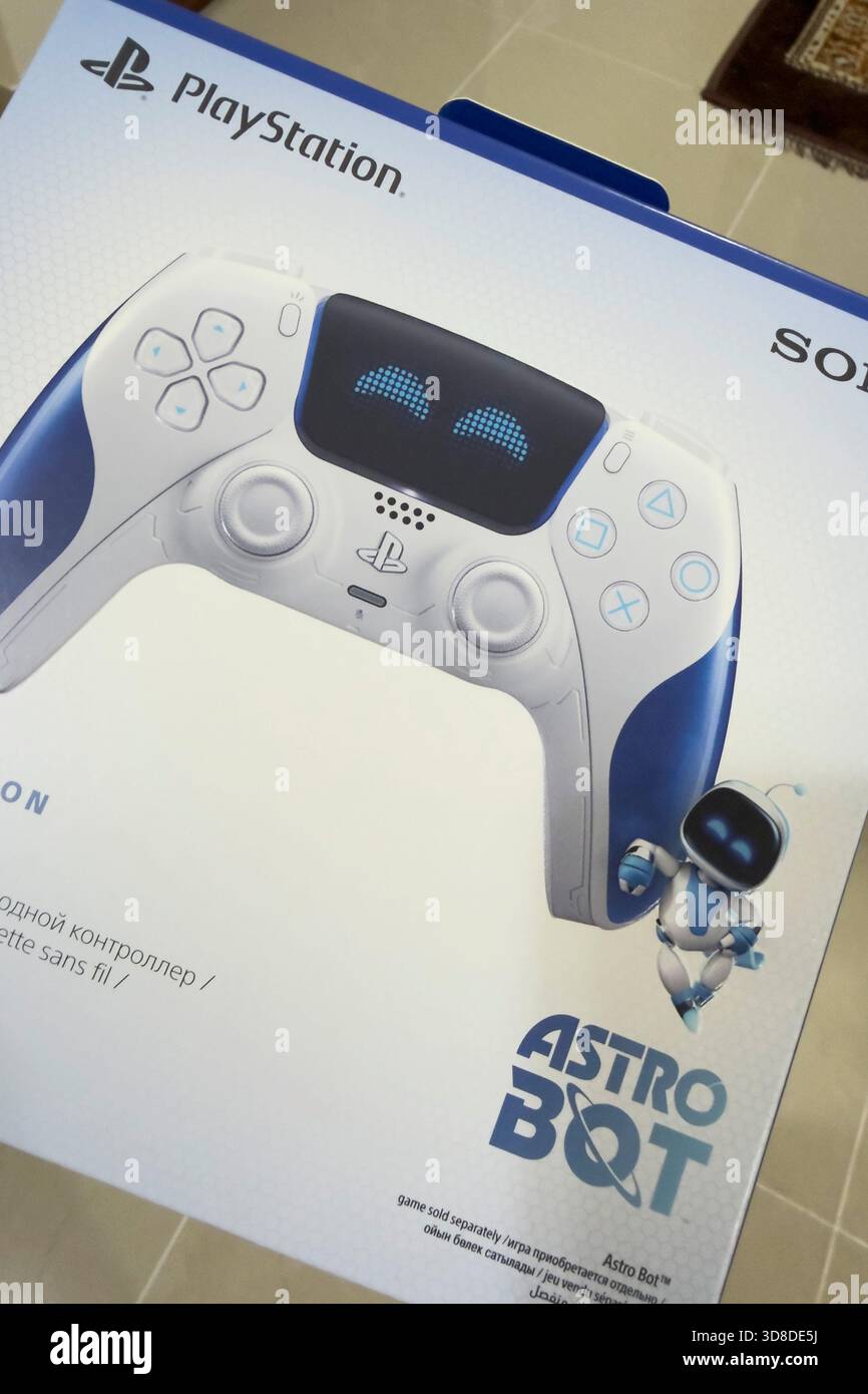 Doha, Katar - 28. November 2025: Ein Spieler spielt zu Hause Play Station 5, seine Hand hält den Dual Sense Joystick, den neuen Wireless Controller. Stockfoto