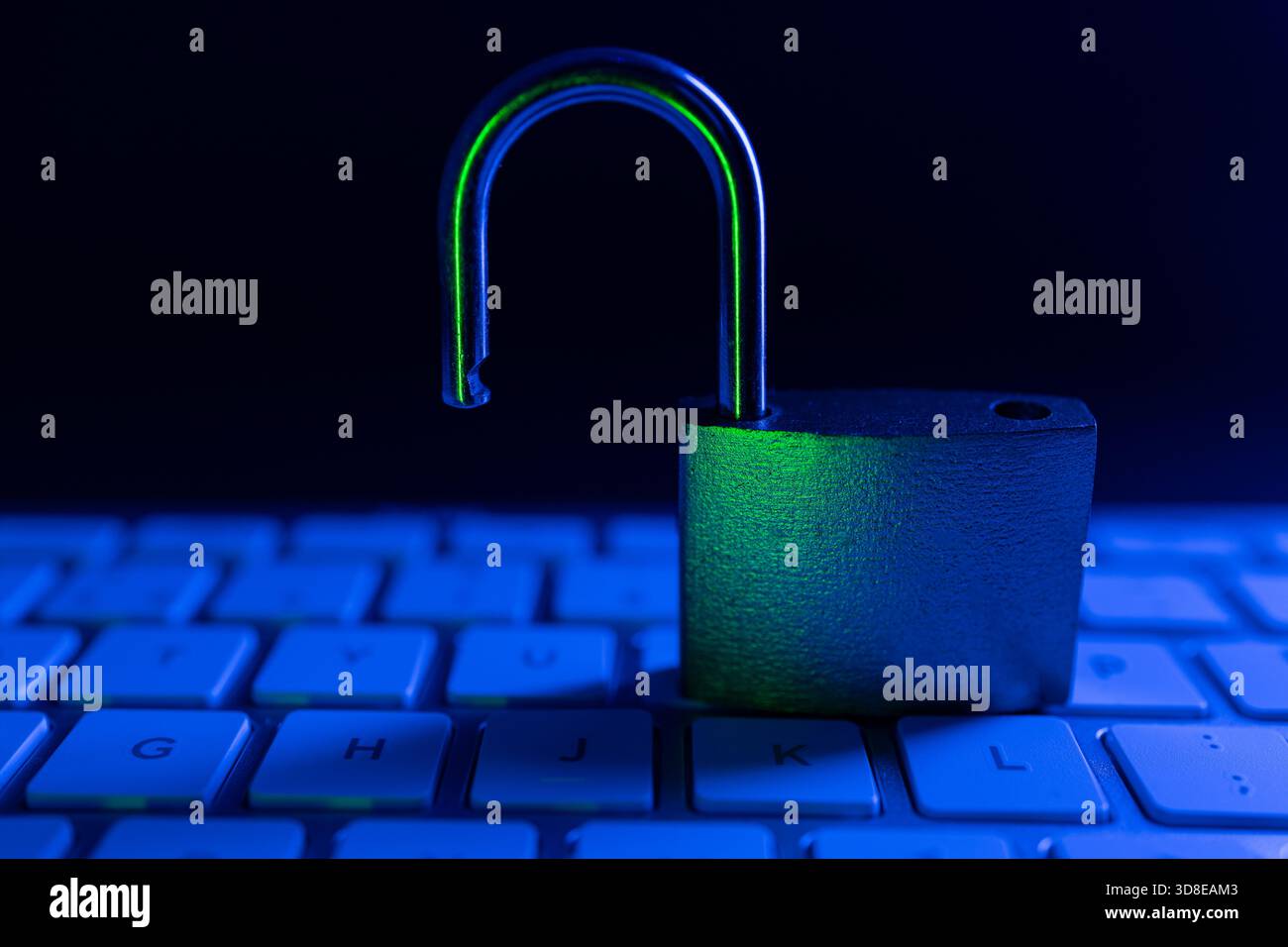 Ein Vorhängeschloss befindet sich aufrecht auf einer Computertastatur und hebt das Thema Internetsicherheit hervor. Die gedämpfte Beleuchtung und die Blautöne erzeugen ein Gefühl von Stockfoto