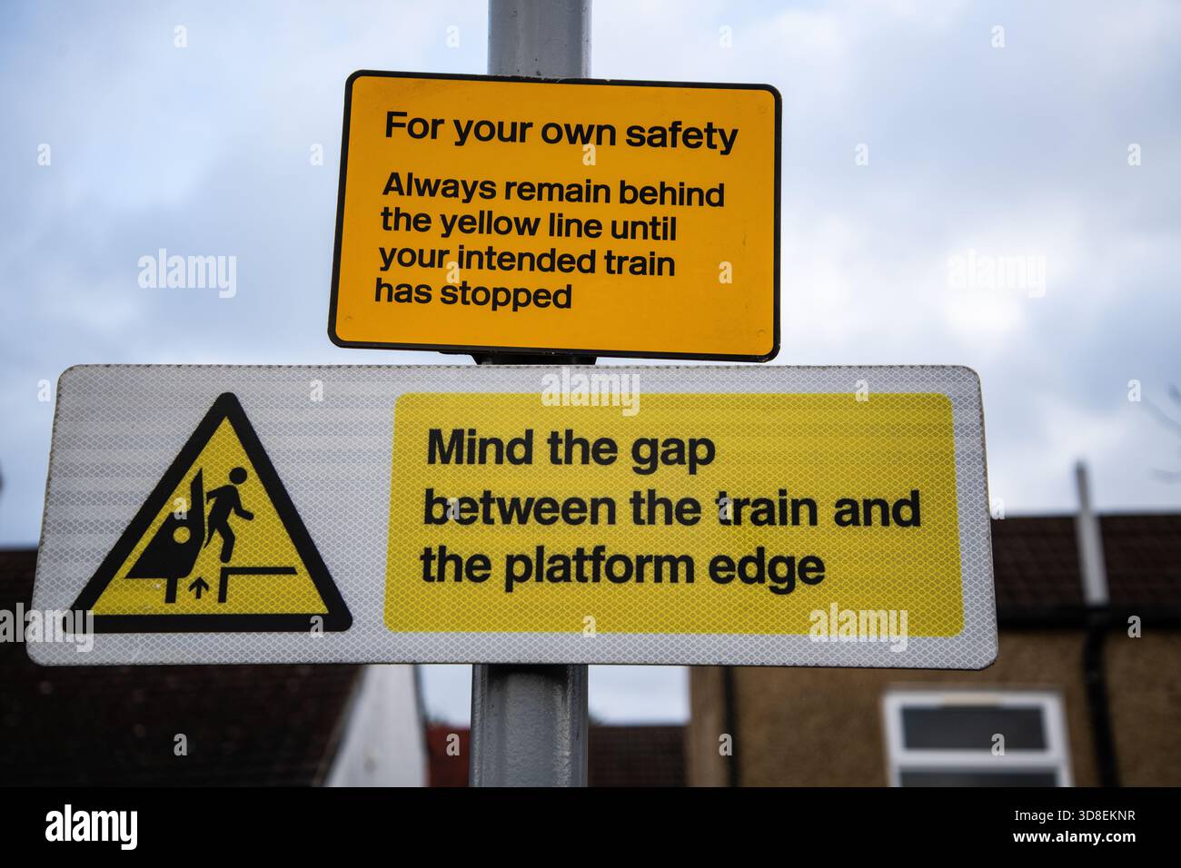 Zwei Warnschilder an Bahnsteigen warnen die Passagiere, hinter der gelben Linie zu bleiben und die Lücke zwischen Zug und Bahnsteig zu beachten. Stockfoto