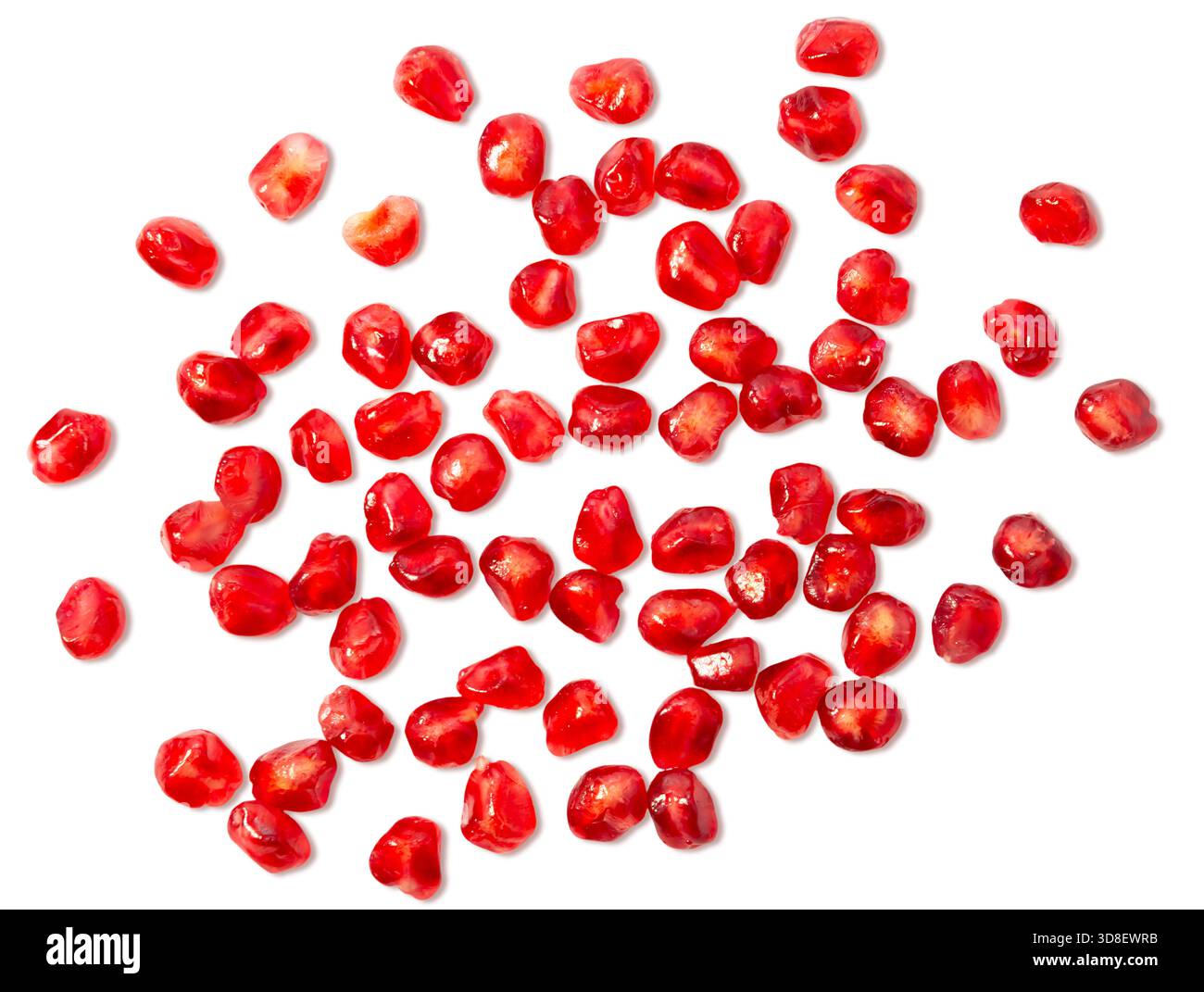 Verstreute Granatapfelkerne bilden einen auffälligen Kontrast vor einem weißen Hintergrund und betonen ihre satte rote Farbe und die glänzende Oberfläche. Stockfoto