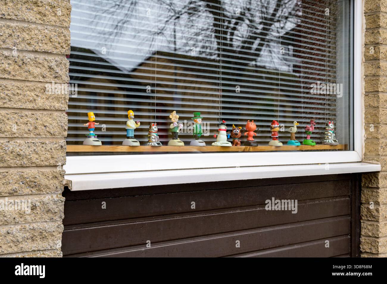 Nickende Figuren auf der Innenseite eines Hausfensters, Großbritannien Stockfoto