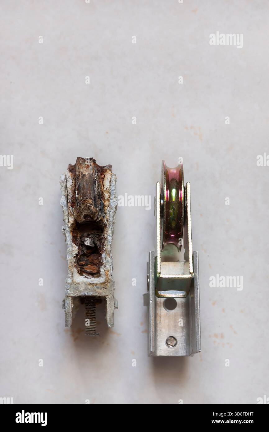 Alte und neue Schiebetürrollen stehen nebeneinander im Kontrast. Stockfoto