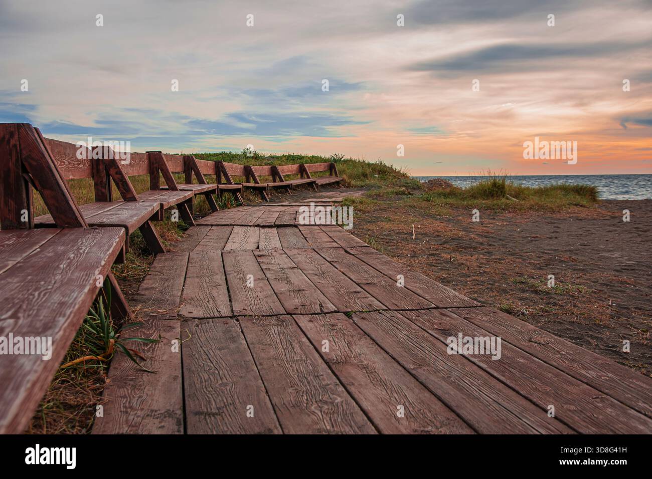 Panoramabänke, auf denen Sie den Sonnenuntergang am Strand von Tarquinia Lido beobachten können Stockfoto