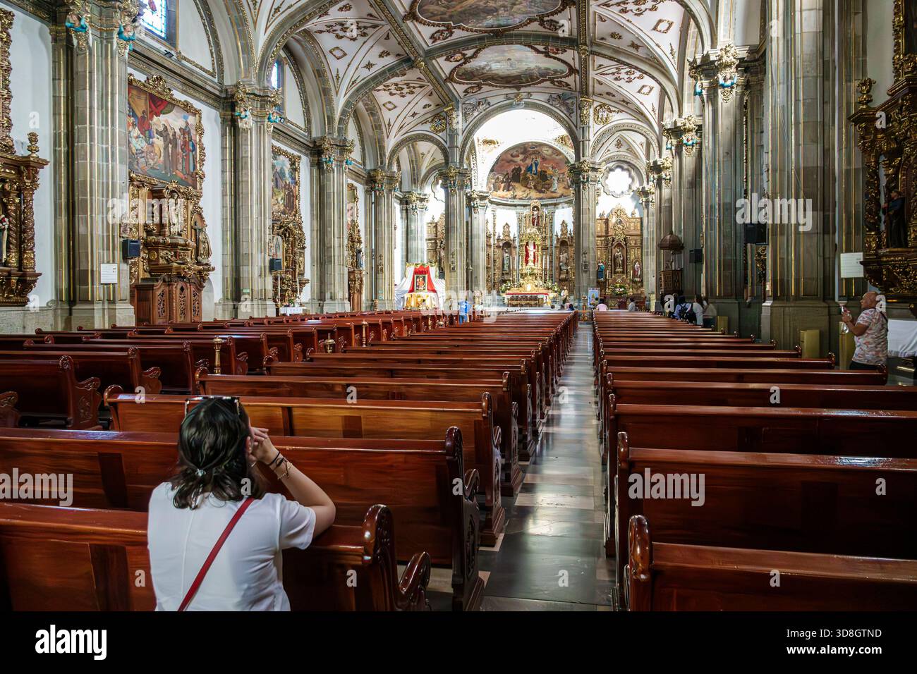 Mexiko-Stadt Mexiko, Coyoacan Parroquia de San Juan Bautista, katholische Pfarrkirche, Innenschiff, Holzbänke mit weitem Blick, verzierte Altäre religiöse Kunst Schmerz Stockfoto